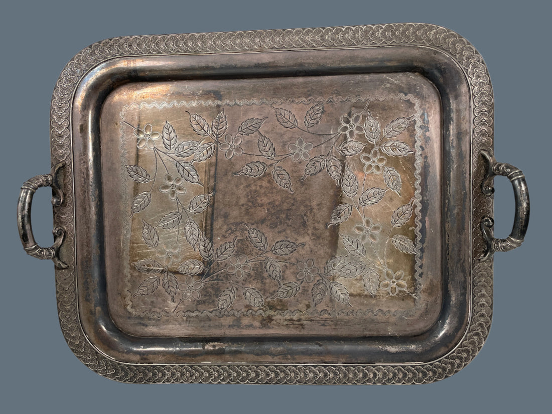 Silver tray with floral embossing on a white background