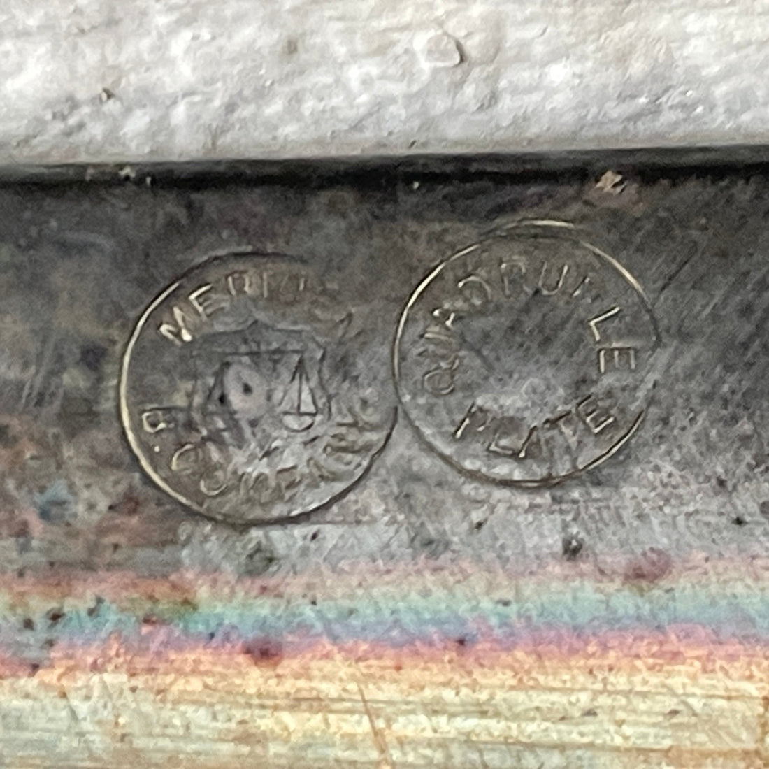 Metal surface with engraved text and a rainbow effect