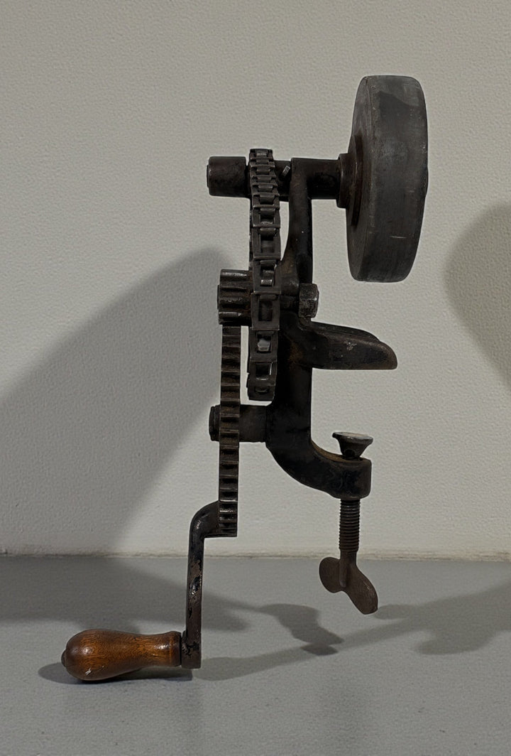 Working antique clamp-on cast-iron grinder with chain drive. Compact 19th-century sharpening tool, fully functional. Industrial décor or collector piece.