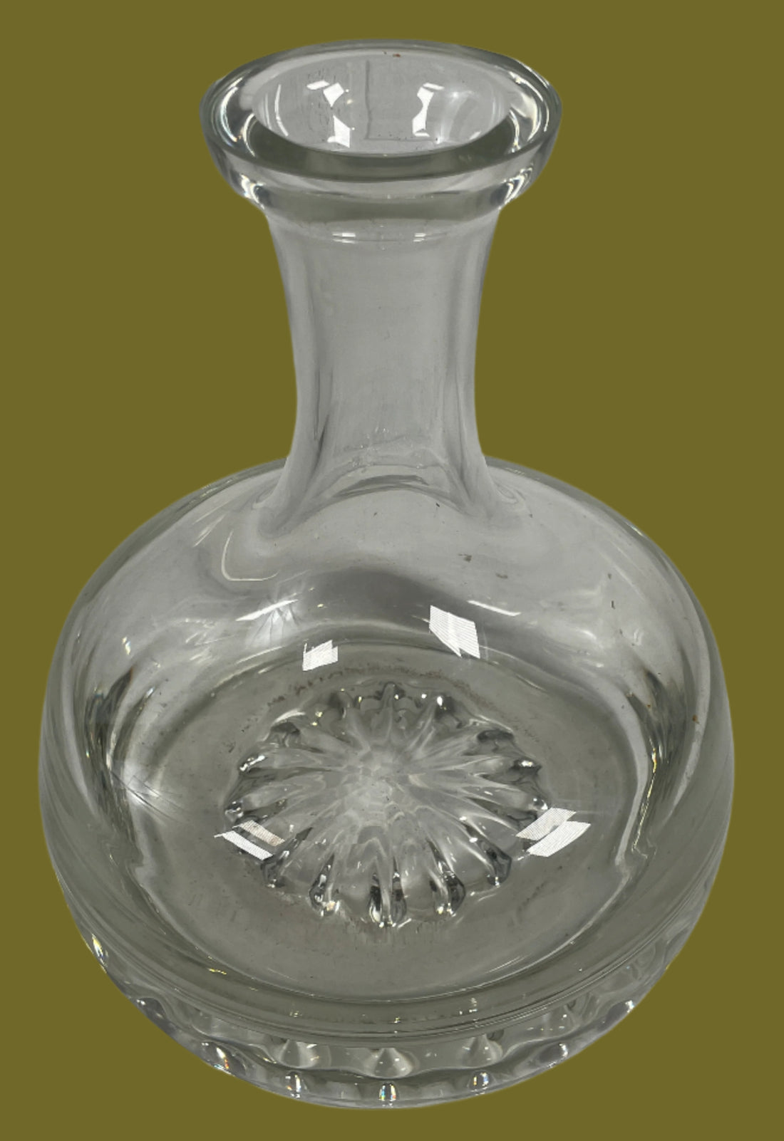 Clear glass decanter with a textured stopper on a light gray background