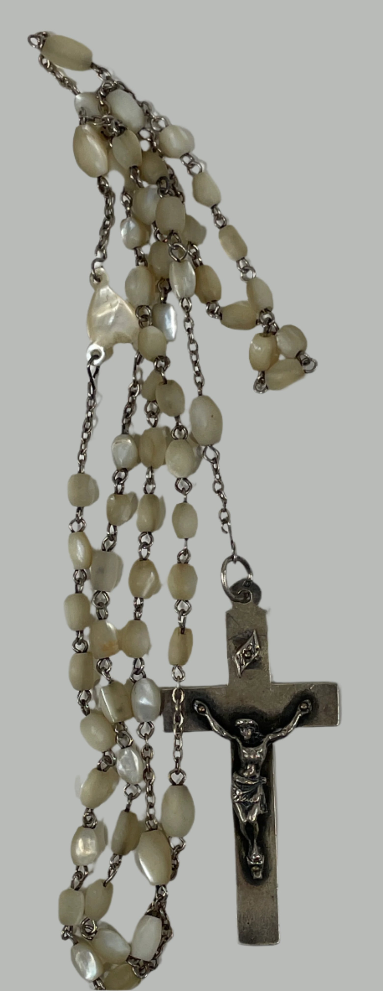 Rosary with stone beads and a cross on a white surface