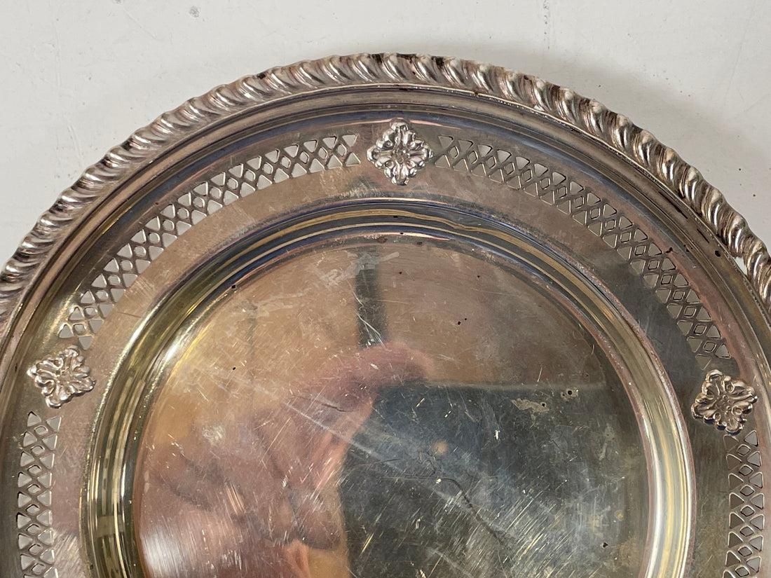 Decorative silver platter with intricate patterns on a white background