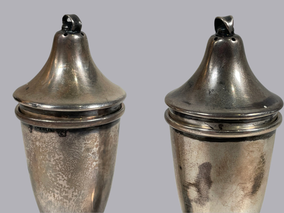 Two silver conical containers with lids on a white background