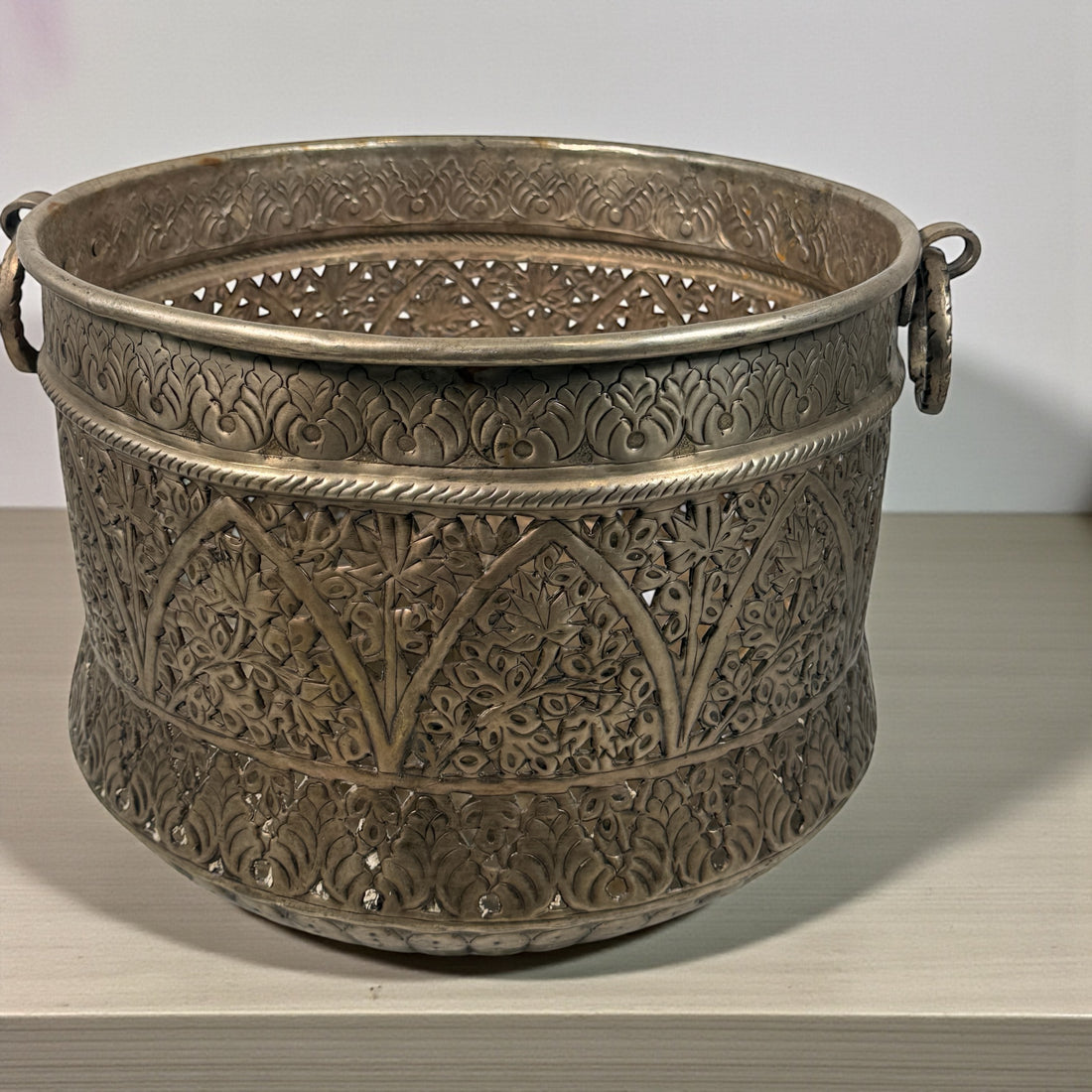 Hand-pierced mid-century Indian brass planter with warm patina and a minor dent. Decorative, collectible, and priced accordingly. Eco Depot Montreal.