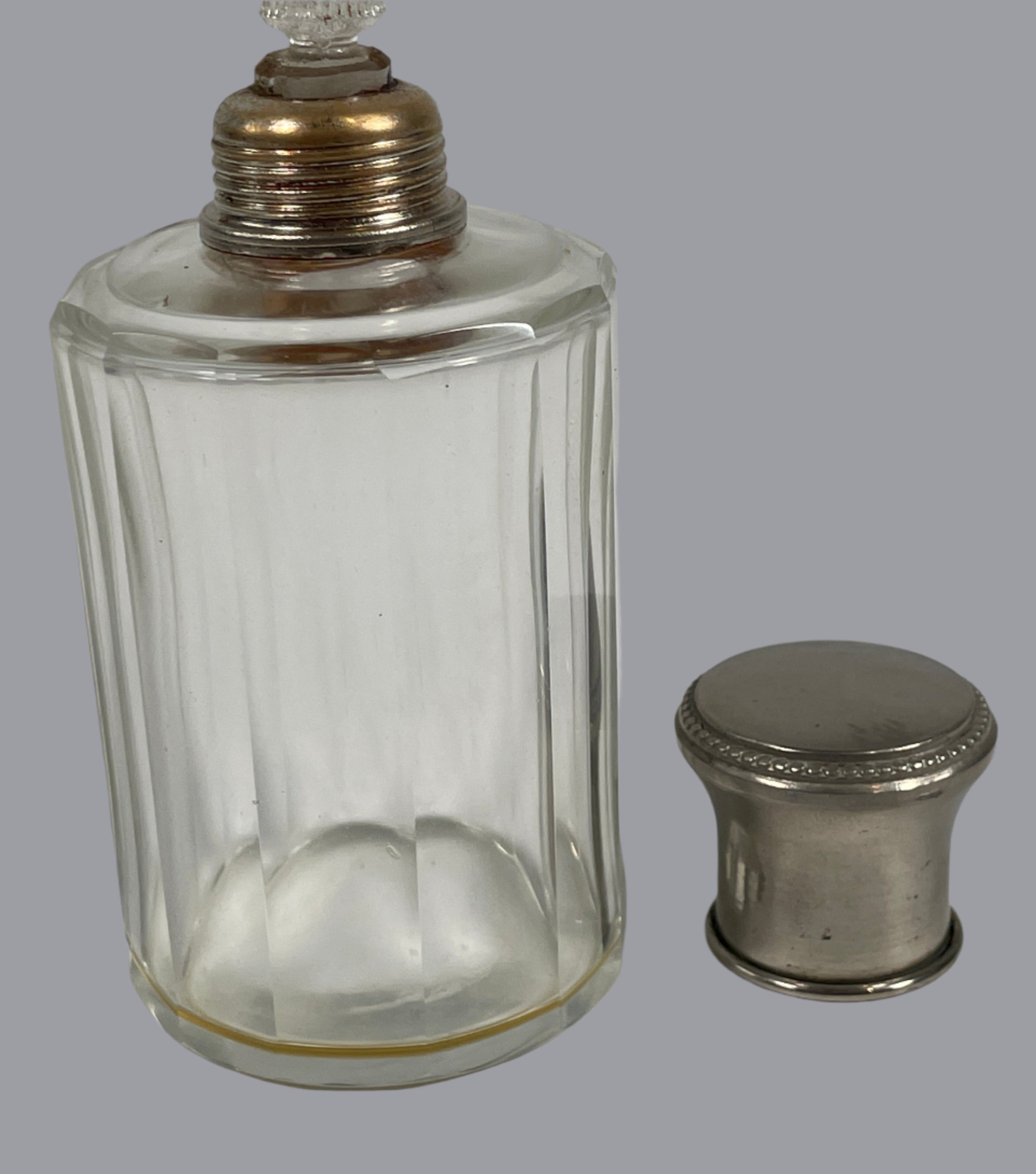 Clear glass bottle with metal cap on a white background