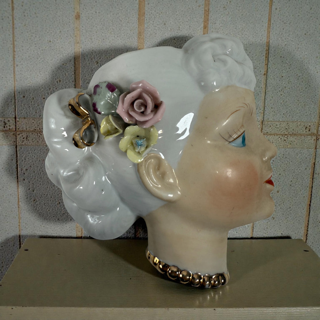 Mid-century Japanese porcelain lady-head wall mask with floral accents. Vintage décor piece with one chipped flower. Ideal for collectors and retro interiors.