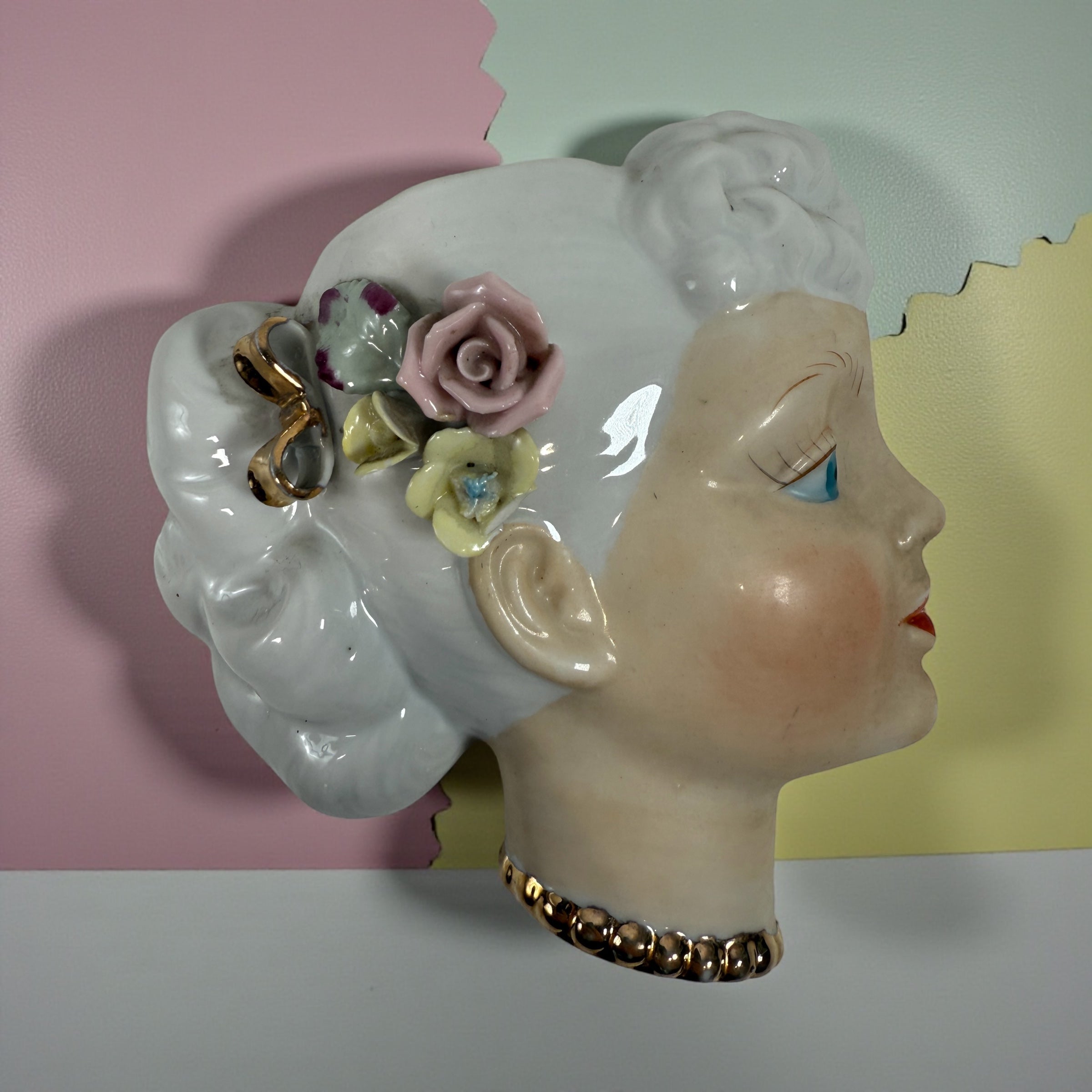 Mid-century Japanese porcelain lady-head wall mask with floral accents. Vintage décor piece with one chipped flower. Ideal for collectors and retro interiors.
