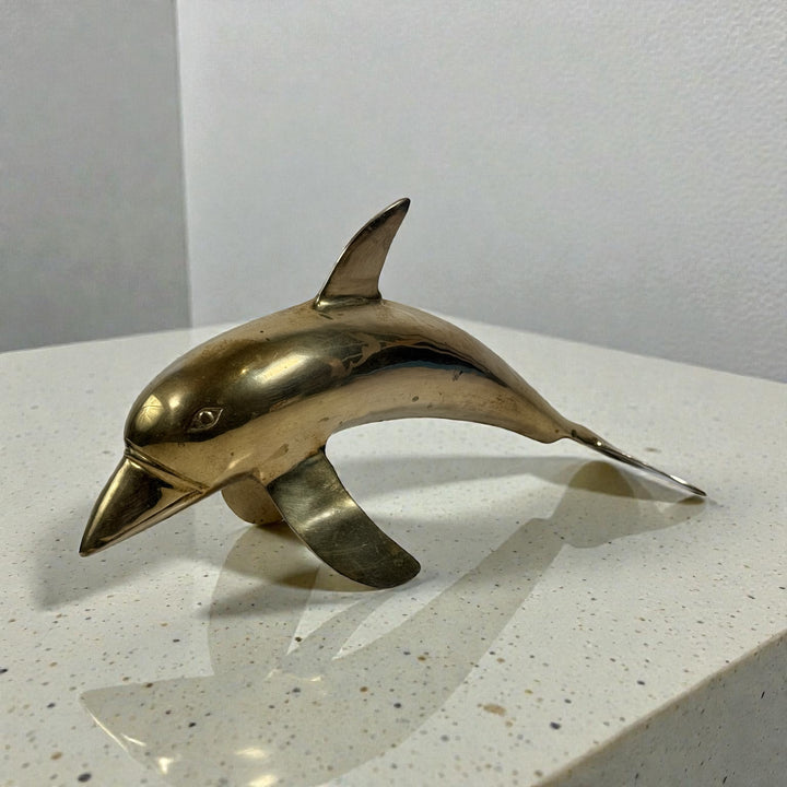 Vintage solid brass dolphin sculpture, mid-century coastal decor accent. Heavy cast brass with original patina. Classic Hollywood Regency style.