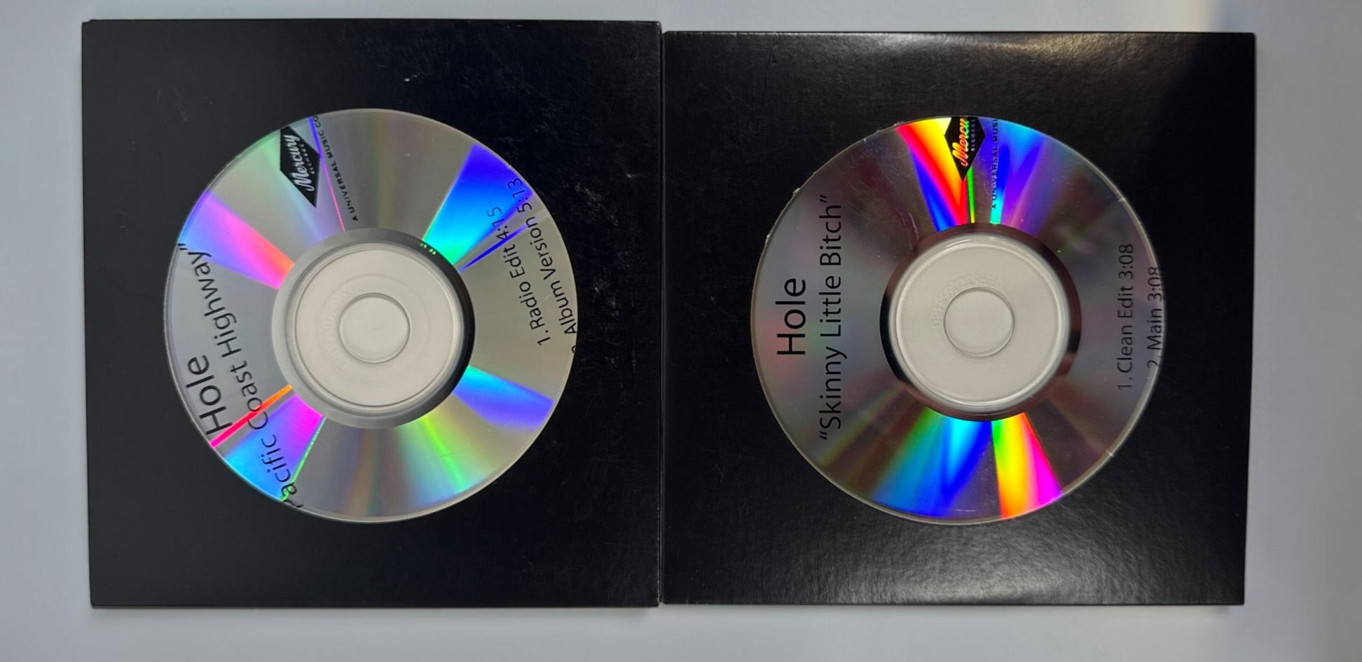Official 2010 Hole Mercury Records promotional CD lot featuring Pacific Coast Highway and Skinny Little Bitch. Includes two original radio promo CDs in paper sleeves.