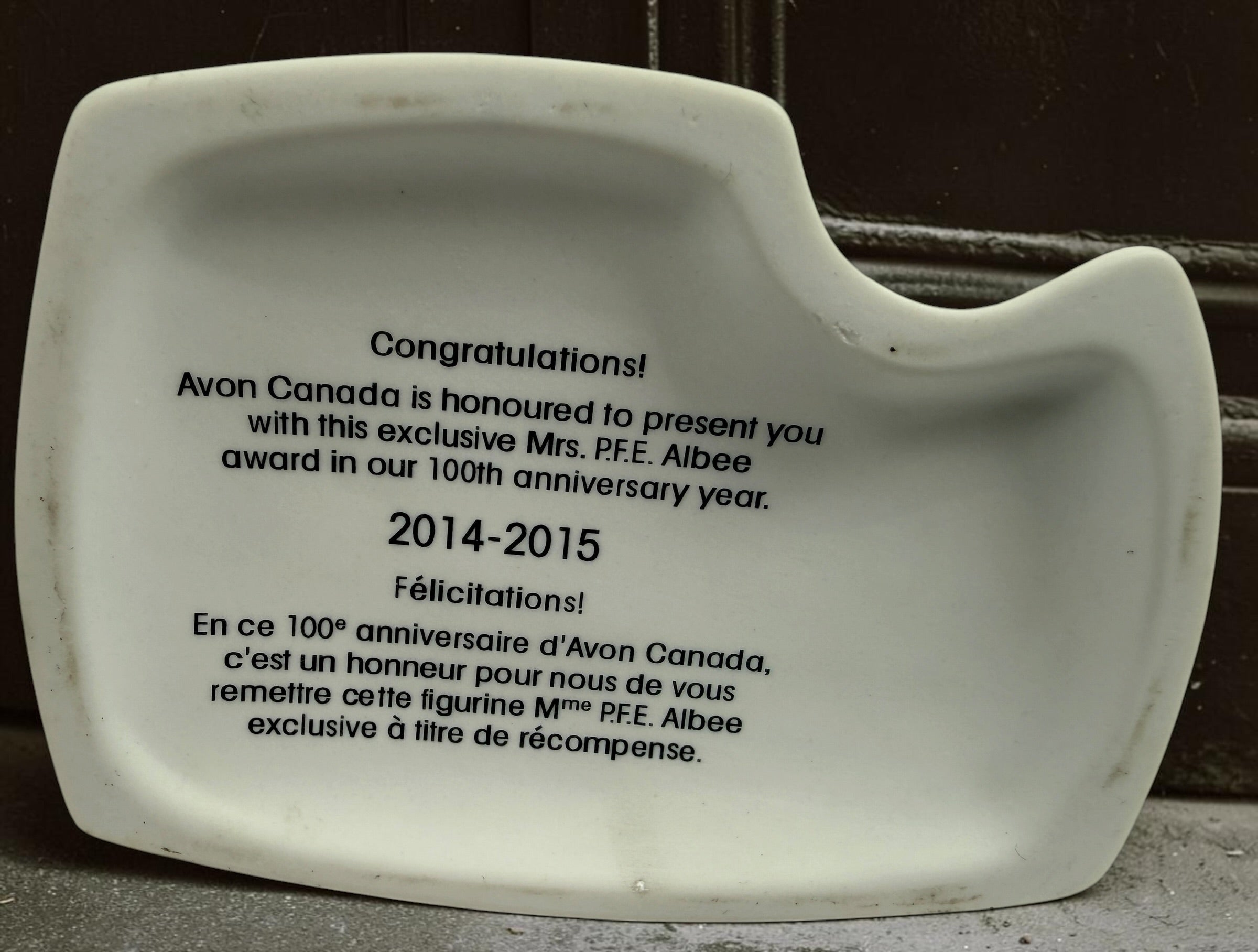 Exclusive Avon Canada 100th anniversary Mrs. P.F.E. Albee figurine award from 2014–2015 featuring a winter skating theme and original commemorative inscription.