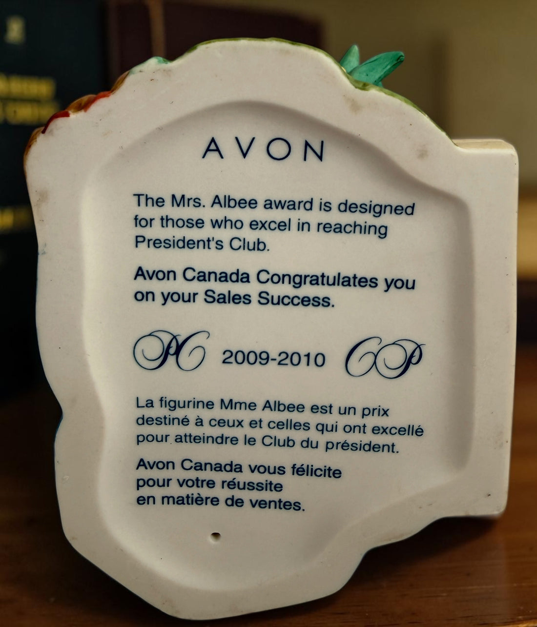 Avon Canada Mrs. Albee President’s Club ceramic figurine from 2009–2010, featuring a Victorian lady in a blue dress with hand-painted details and original inscription.