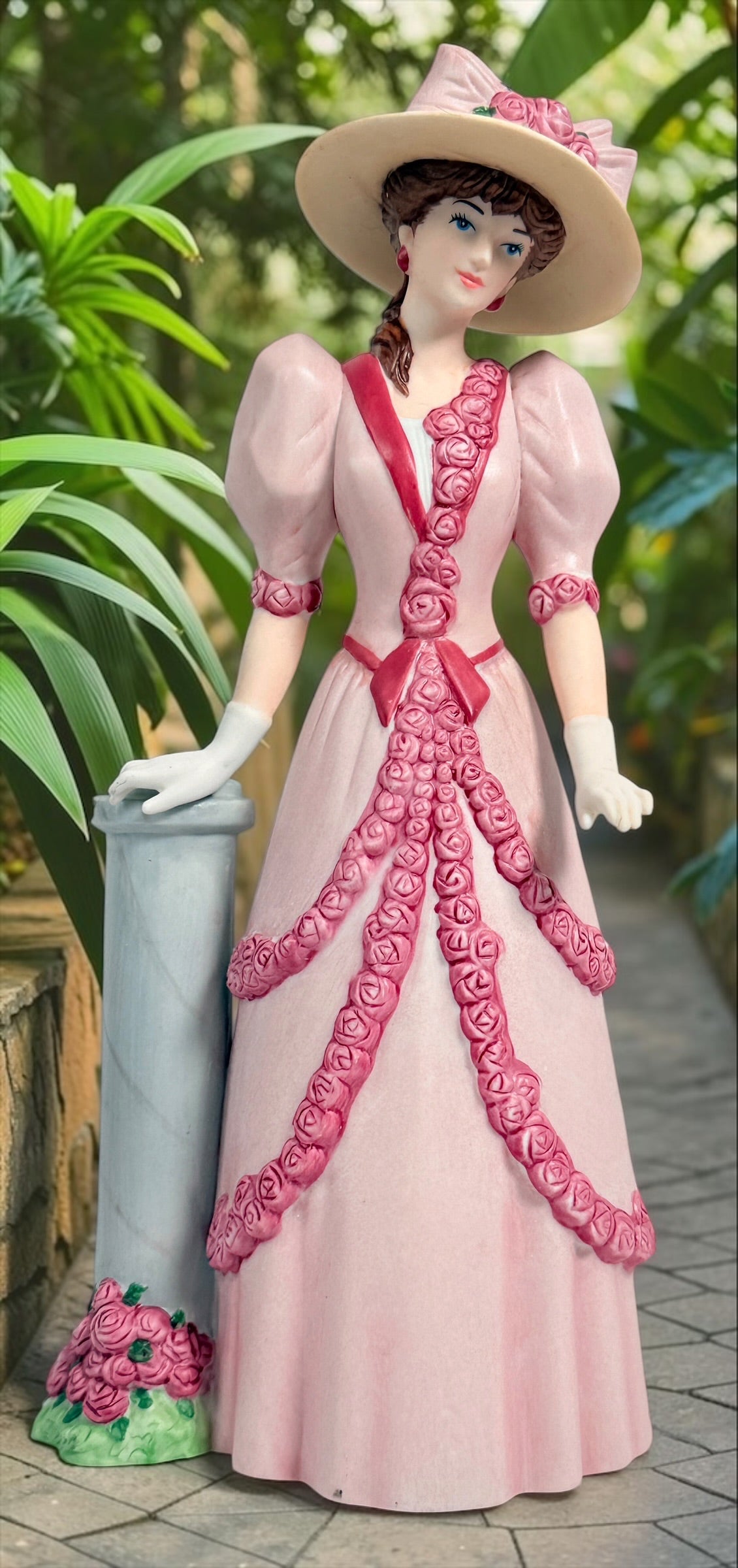 2015 Mrs. Albee Avon commemorative figurine featuring a Victorian lady in a pink rose-trimmed dress with marble-look column. Ceramic collectible award statue.
