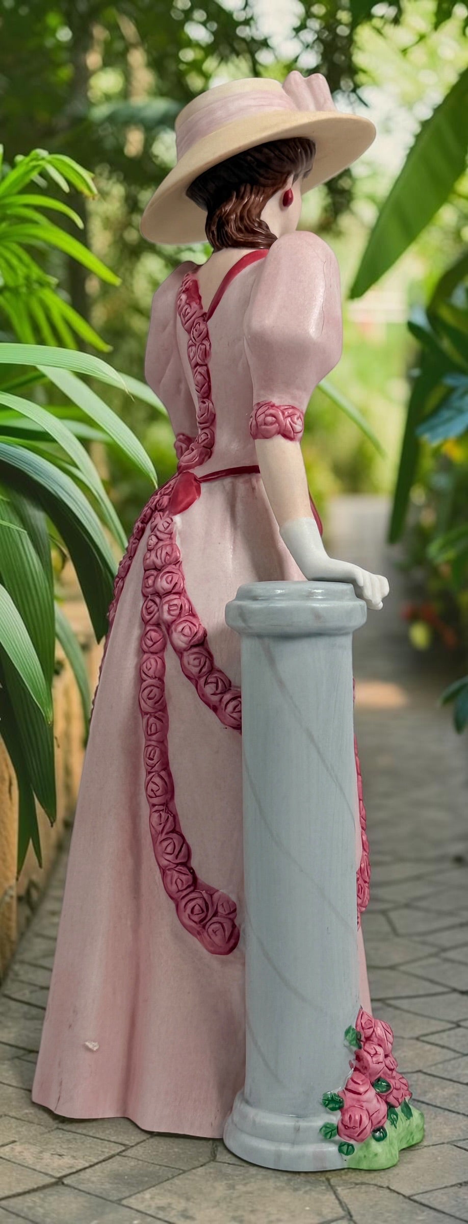 2015 Mrs. Albee Avon commemorative figurine featuring a Victorian lady in a pink rose-trimmed dress with marble-look column. Ceramic collectible award statue.