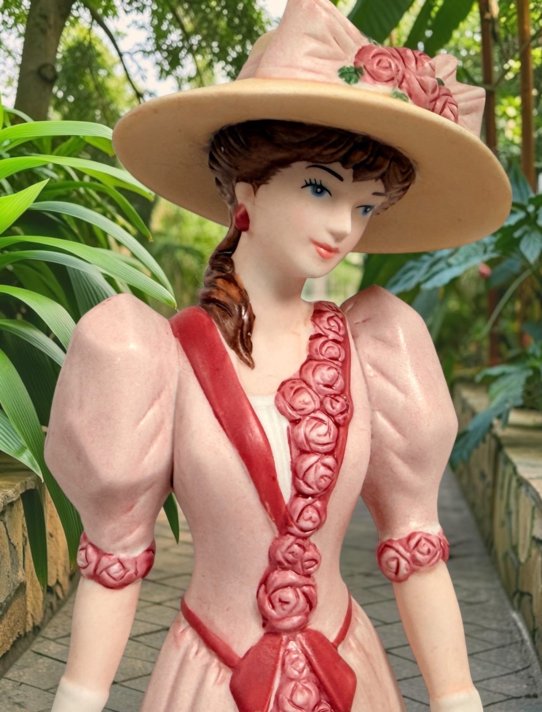 2015 Mrs. Albee Avon commemorative figurine featuring a Victorian lady in a pink rose-trimmed dress with marble-look column. Ceramic collectible award statue.