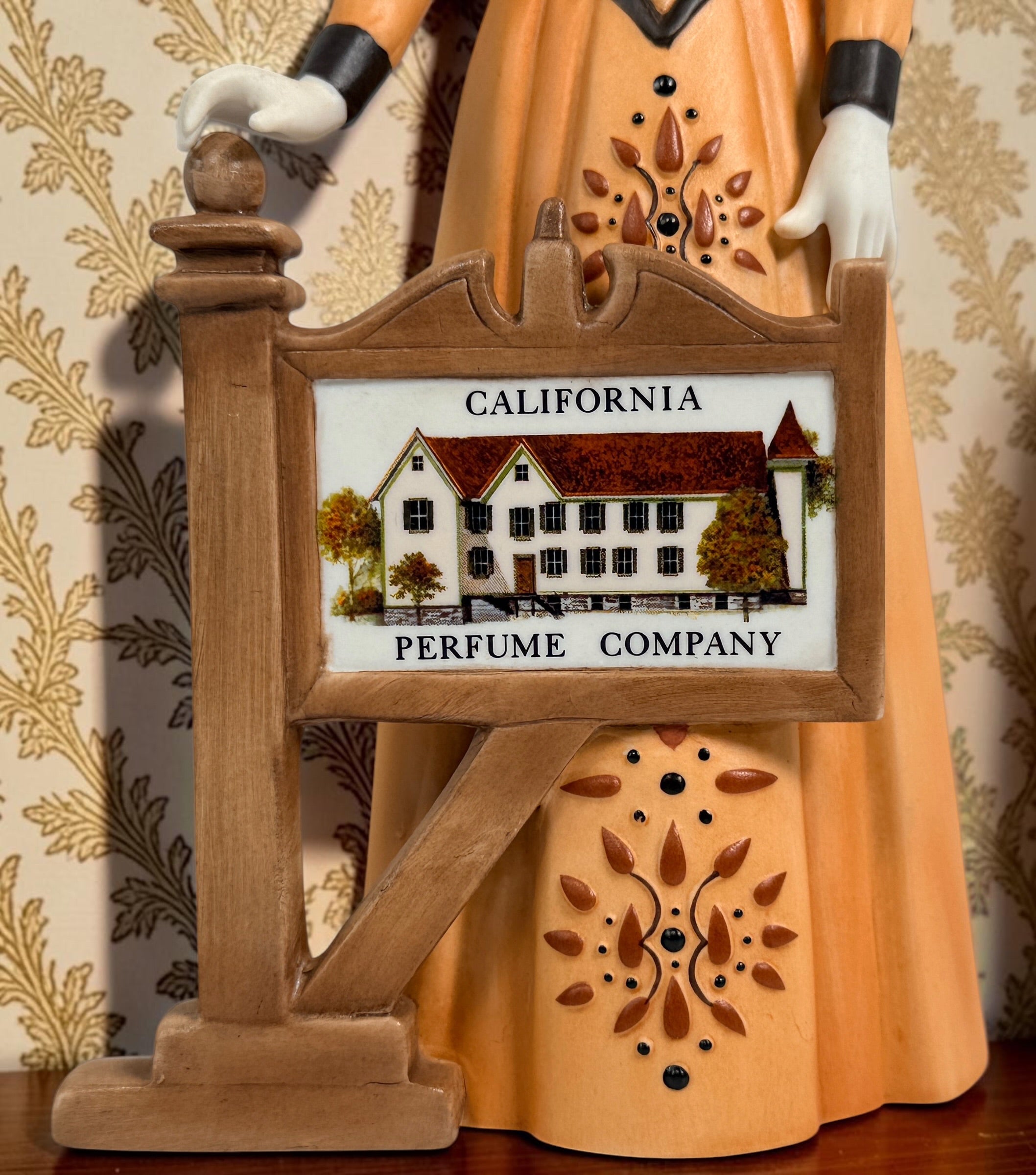2013–2014 Avon Mrs. P.F.E. Albee award figurine featuring the California Perfume Company sign and Victorian dress. Ceramic collectible in good condition.