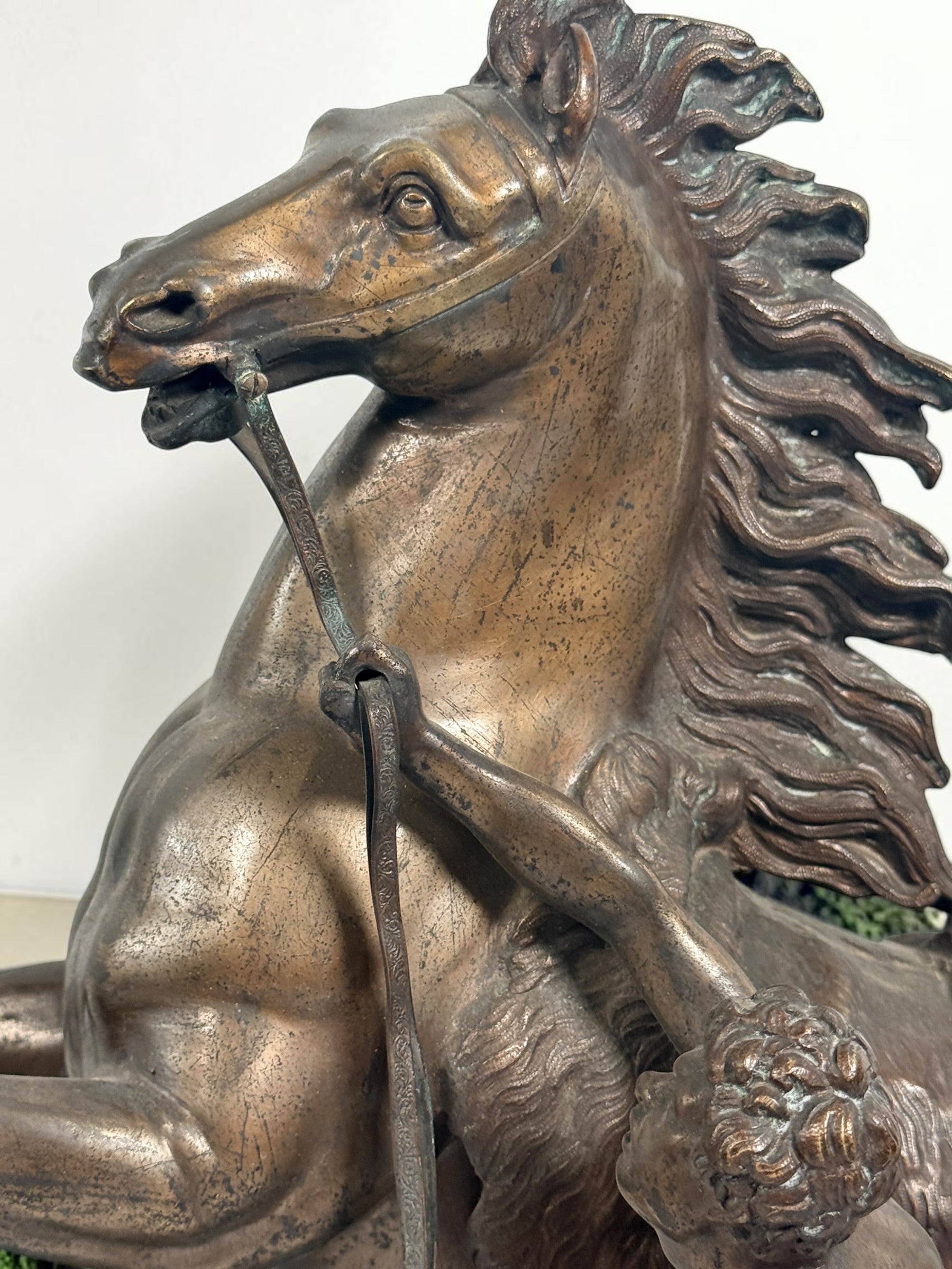 Antique Horse of Marly sculpture after Guillaume Coustou in patinated spelter, circa 1880–1910. Signed “Coustou,” featuring a dramatic horse tamer composition.