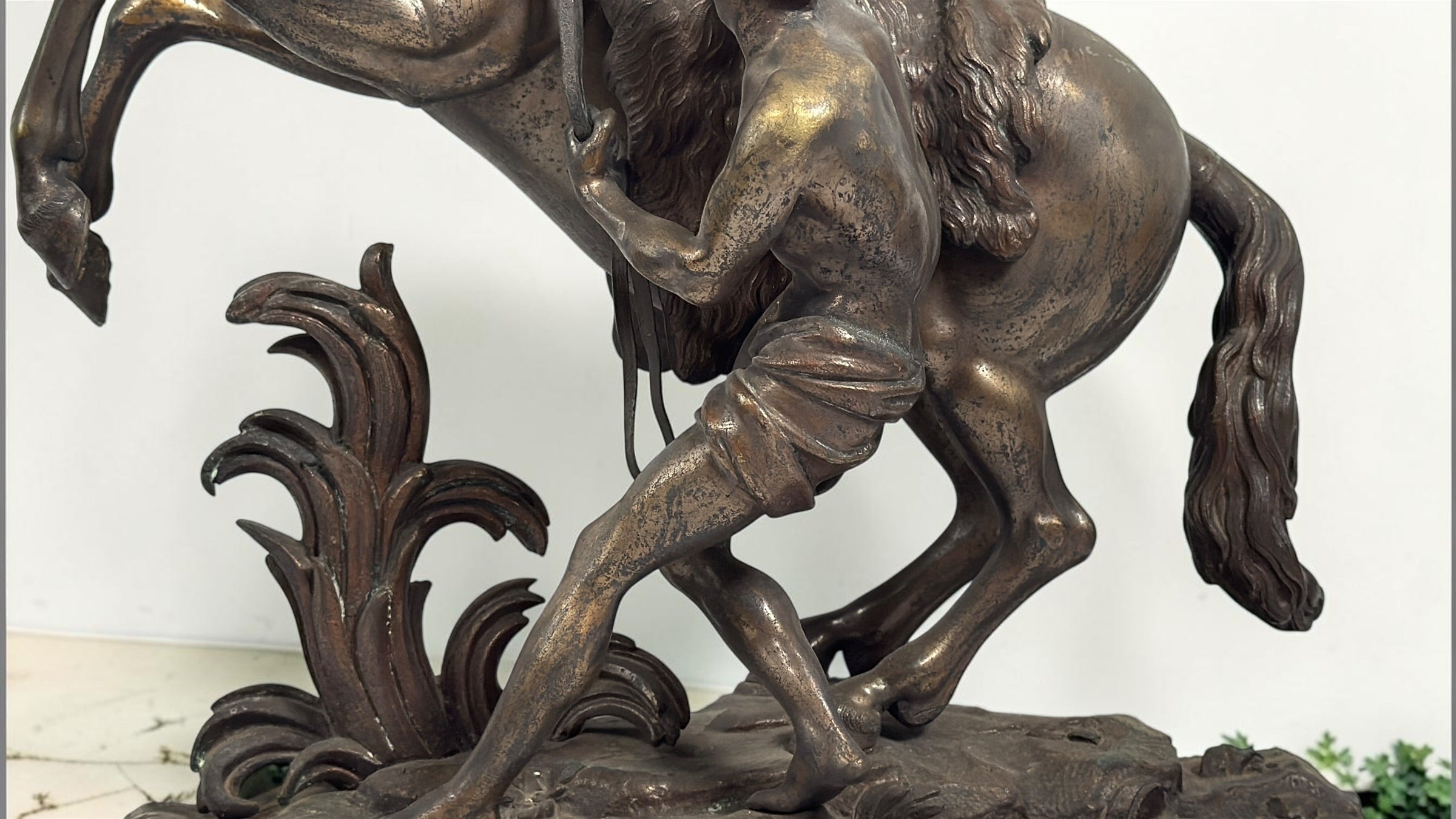 Antique Horse of Marly sculpture after Guillaume Coustou in patinated spelter, circa 1880–1910. Signed “Coustou,” featuring a dramatic horse tamer composition.