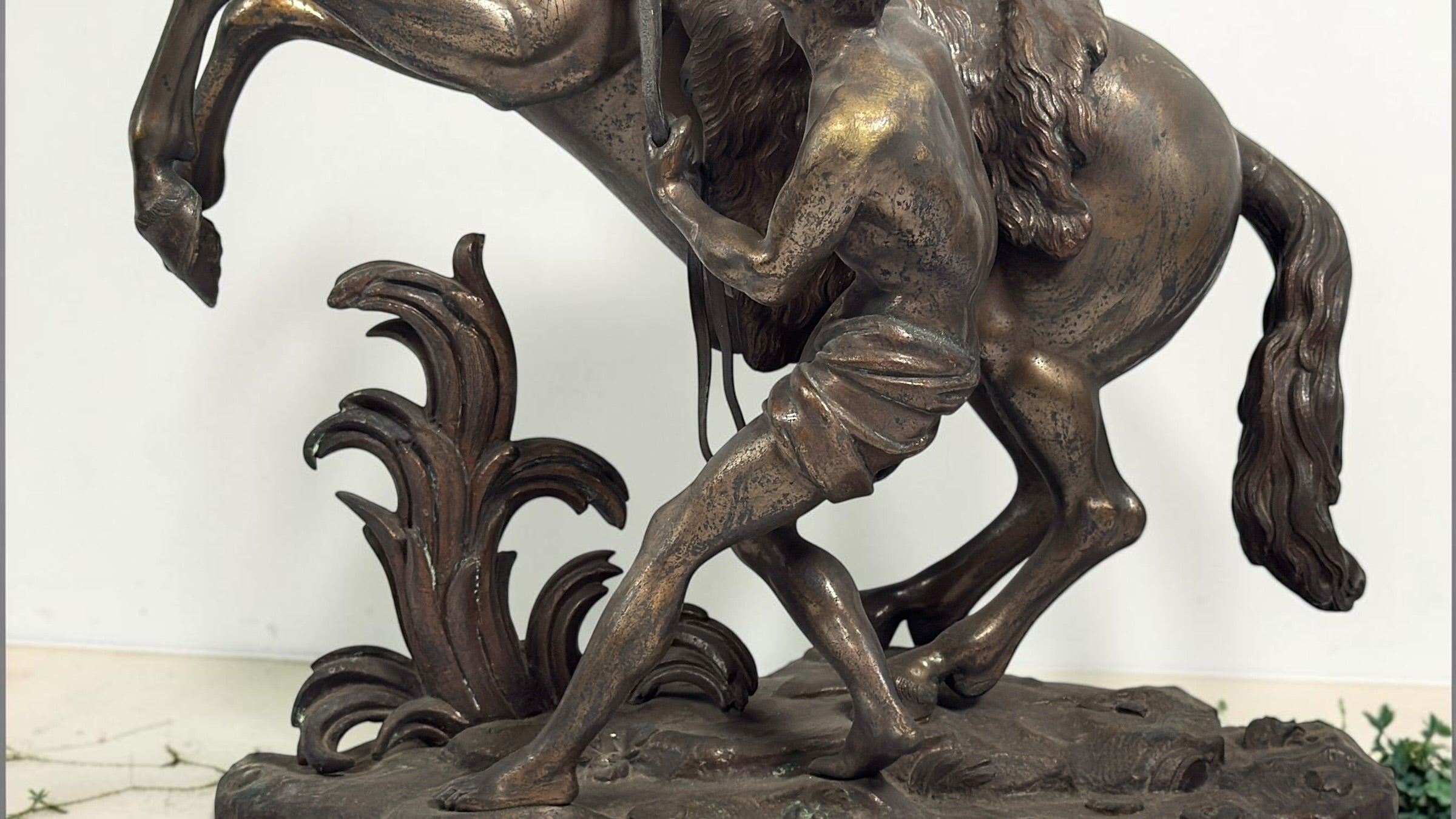 Antique Horse of Marly sculpture after Guillaume Coustou in patinated spelter, circa 1880–1910. Signed “Coustou,” featuring a dramatic horse tamer composition.