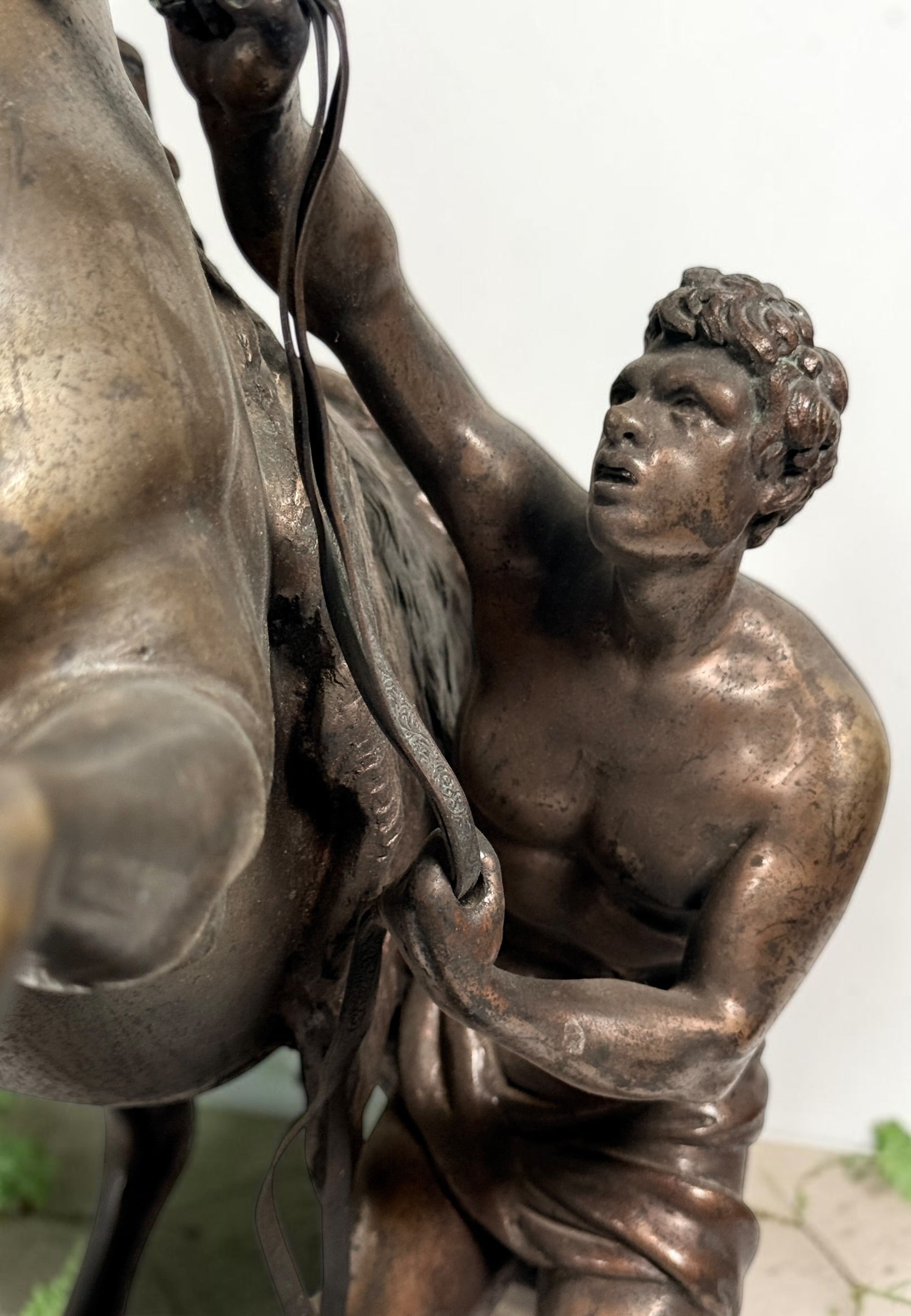 Antique Horse of Marly sculpture after Guillaume Coustou in patinated spelter, circa 1880–1910. Signed “Coustou,” featuring a dramatic horse tamer composition.