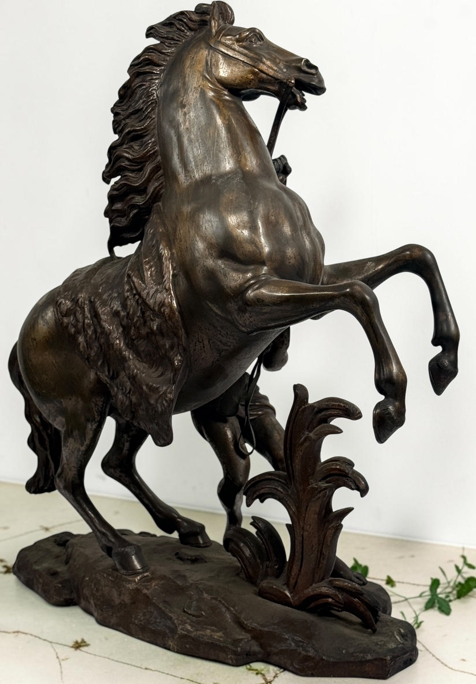 Antique Horse of Marly sculpture after Guillaume Coustou in patinated spelter, circa 1880–1910. Signed “Coustou,” featuring a dramatic horse tamer composition.