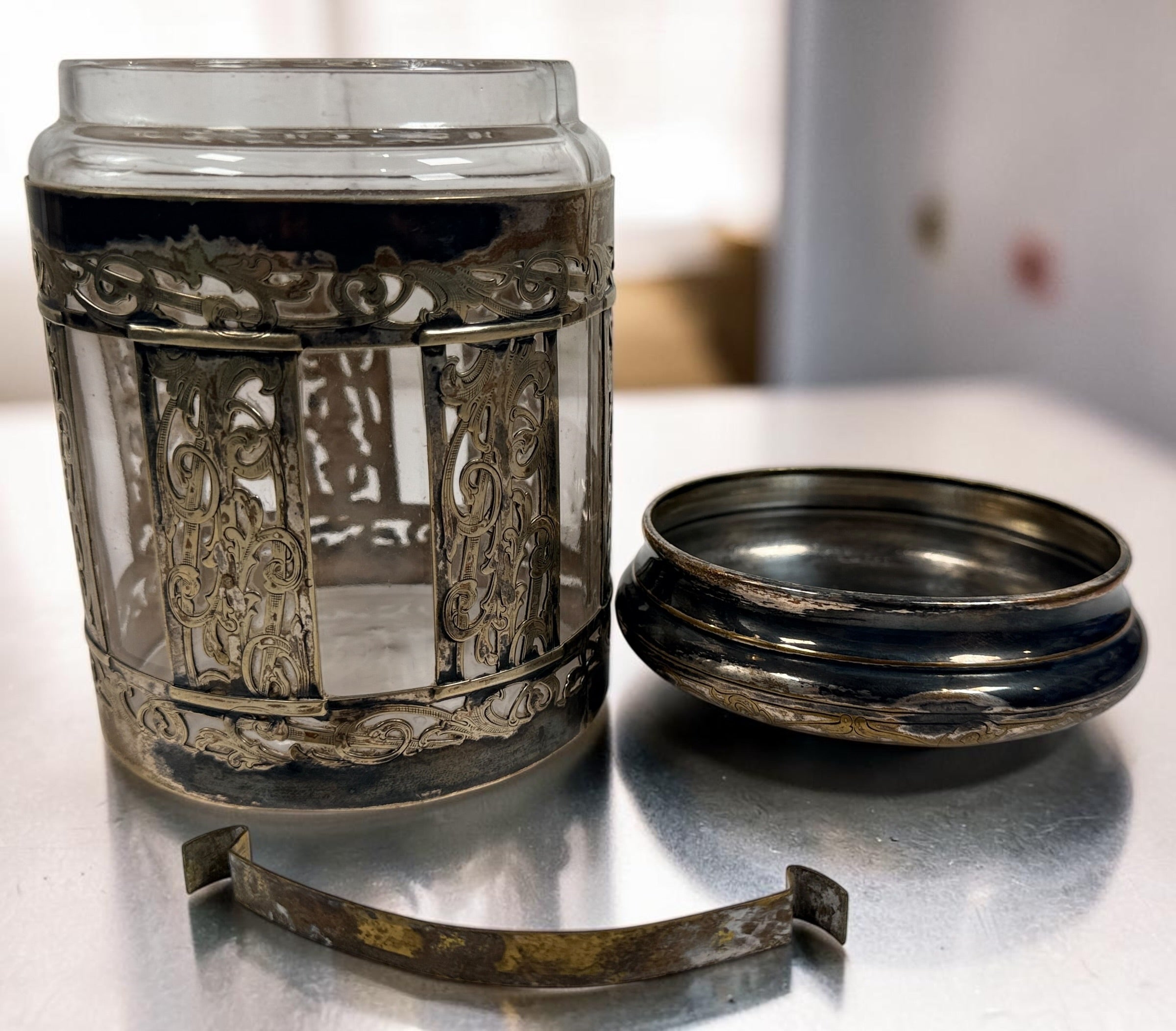 Antique Victorian glass tobacco humidor with ornate German silver overlay, engraved floral motifs, and domed lid. Elegant late-19th-century decorative storage jar.