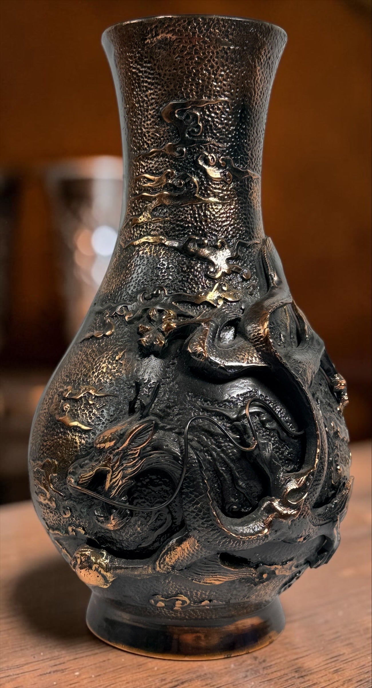 Japanese Meiji-style dragon vase in cast metal with dark bronze finish. Features high-relief dragon decoration, textured surface, and stands 12 inches tall.