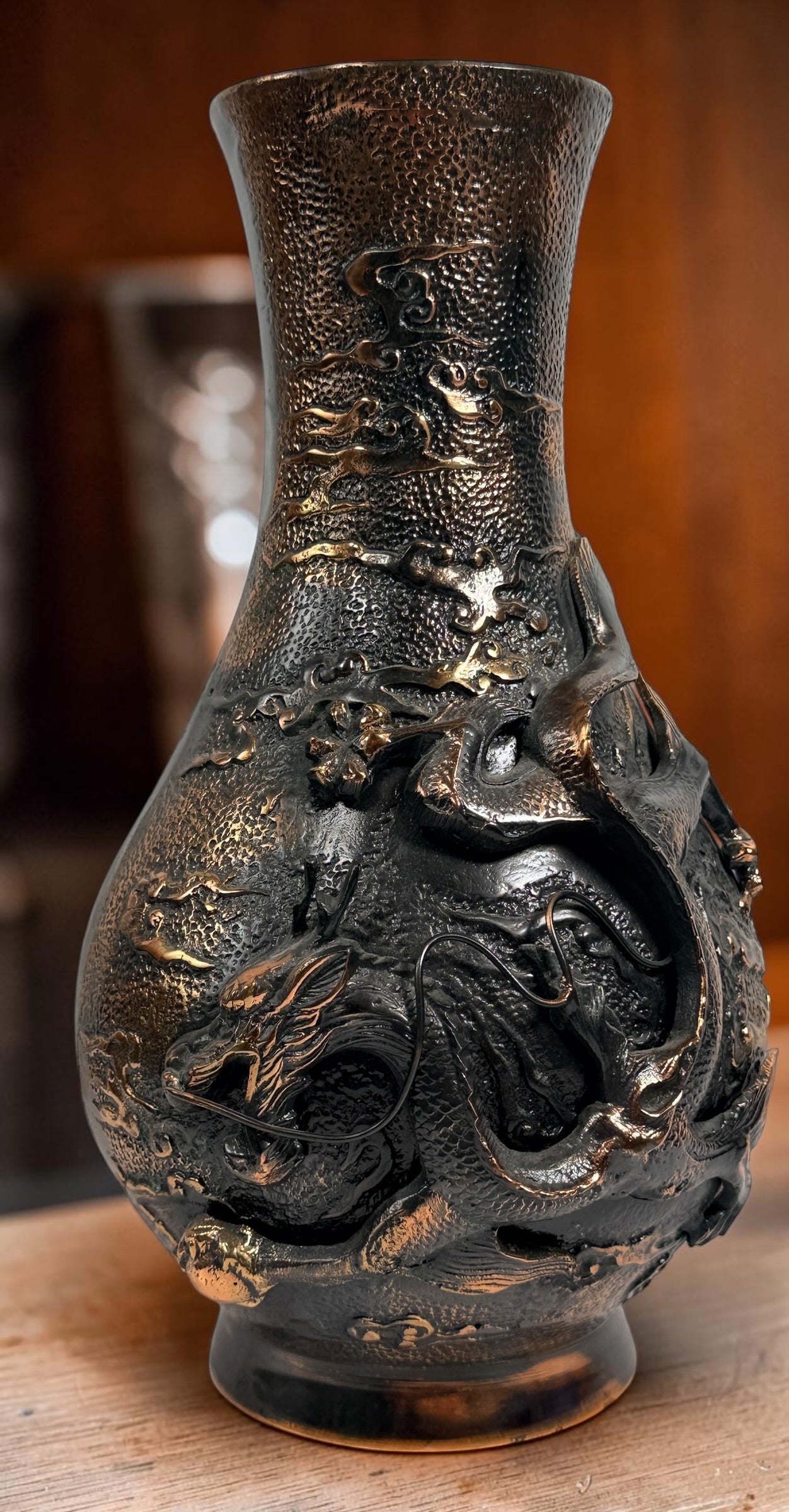 Japanese Meiji-style dragon vase in cast metal with dark bronze finish. Features high-relief dragon decoration, textured surface, and stands 12 inches tall.
