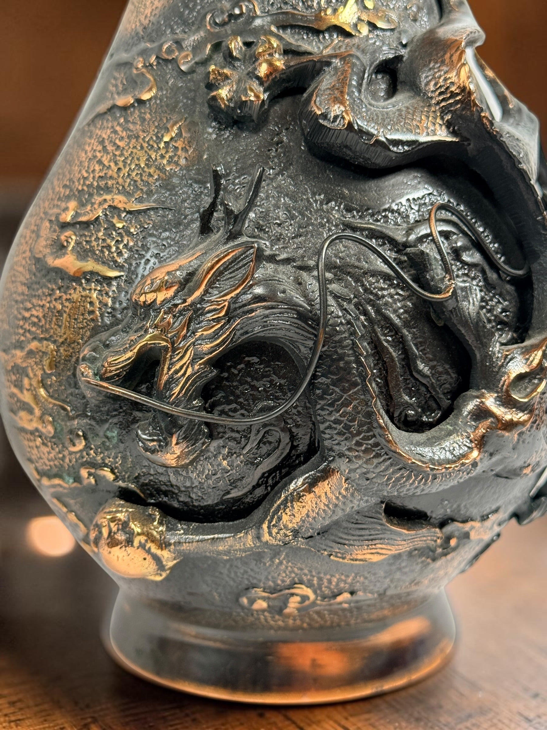 Japanese Meiji-style dragon vase in cast metal with dark bronze finish. Features high-relief dragon decoration, textured surface, and stands 12 inches tall.