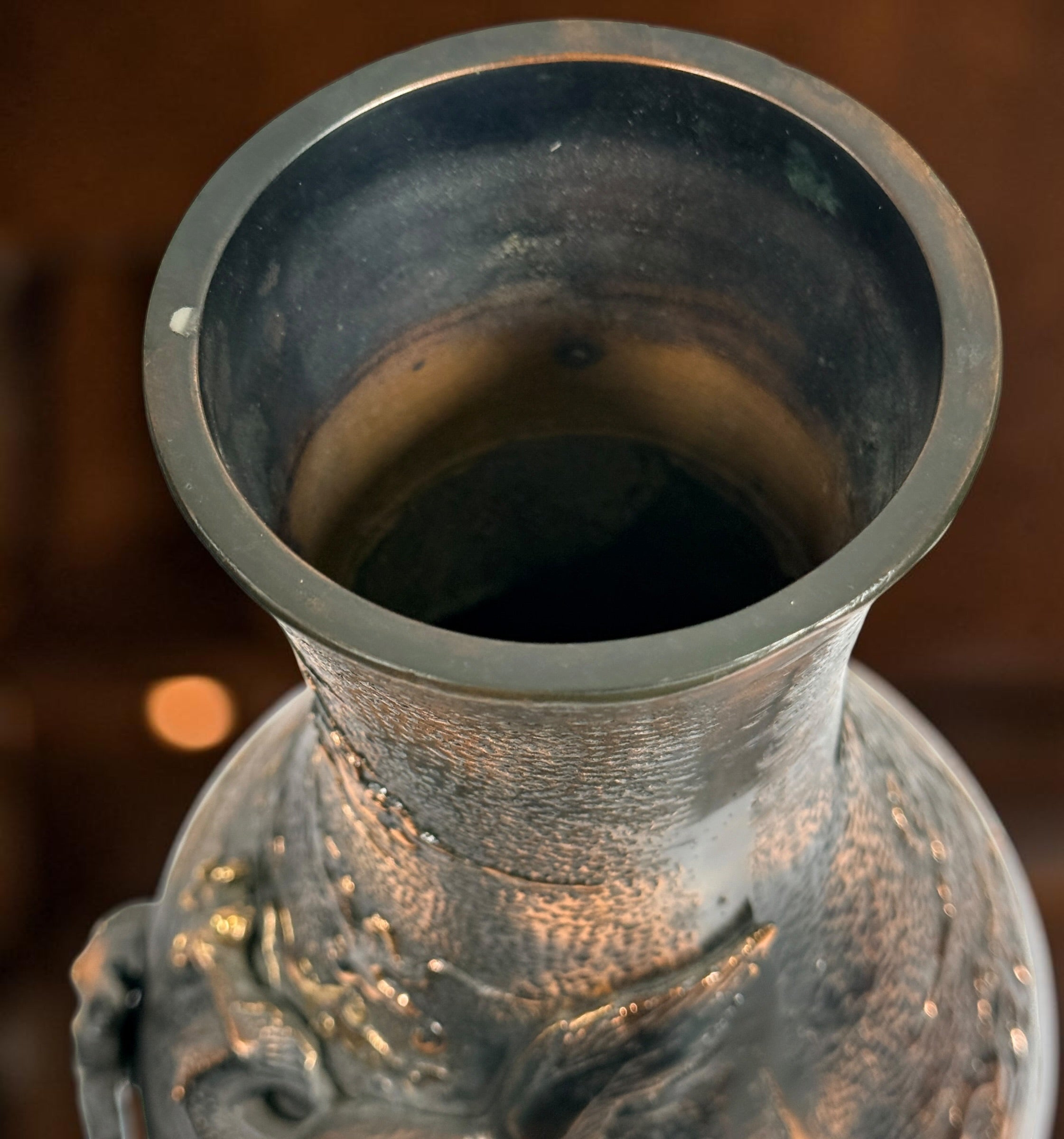 Japanese Meiji-style dragon vase in cast metal with dark bronze finish. Features high-relief dragon decoration, textured surface, and stands 12 inches tall.