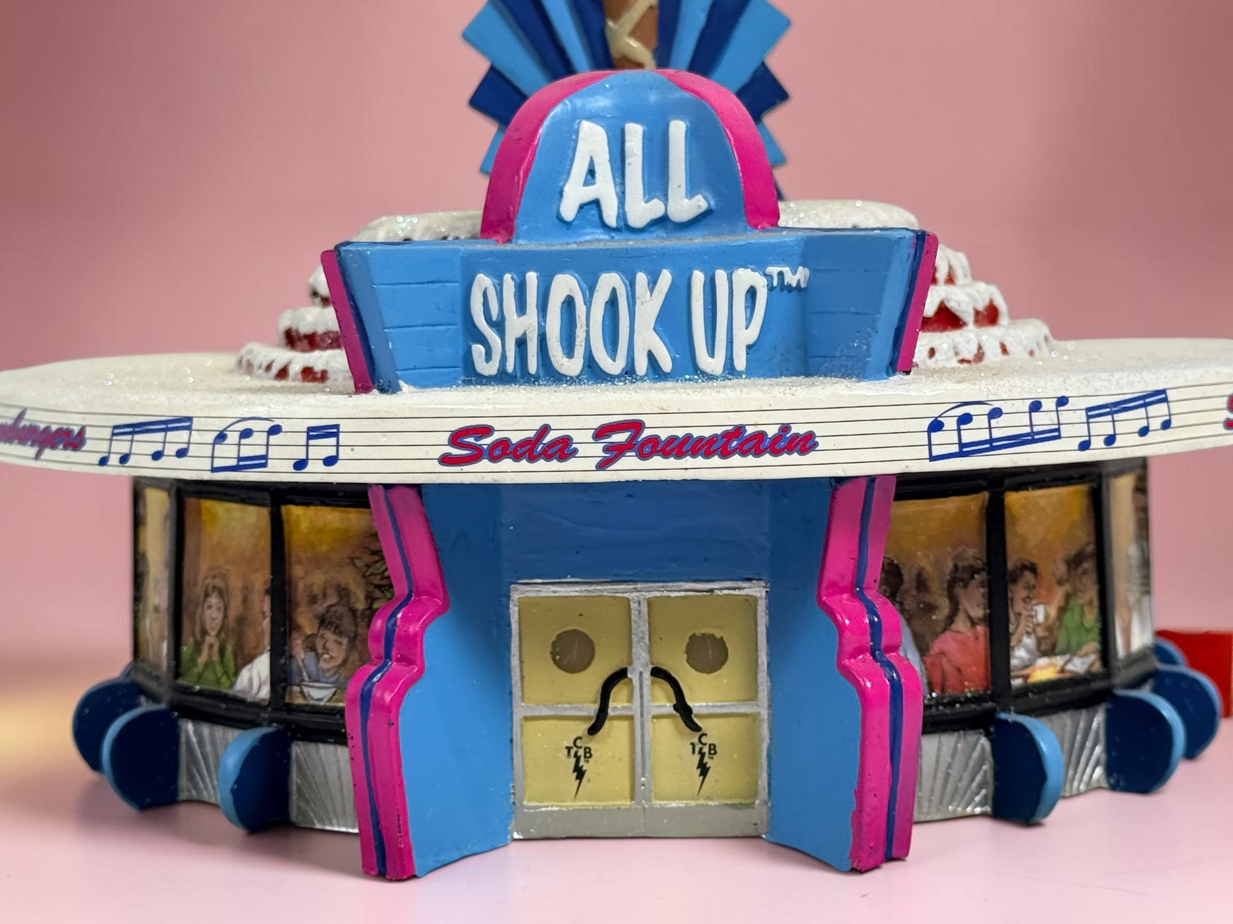 Official 2005 Hawthorne Village “All Shook Up” Soda Fountain from the Elvis Presley Rock ‘n’ Roll Holiday Village collection, featuring colorful retro diner details and snowy accents.