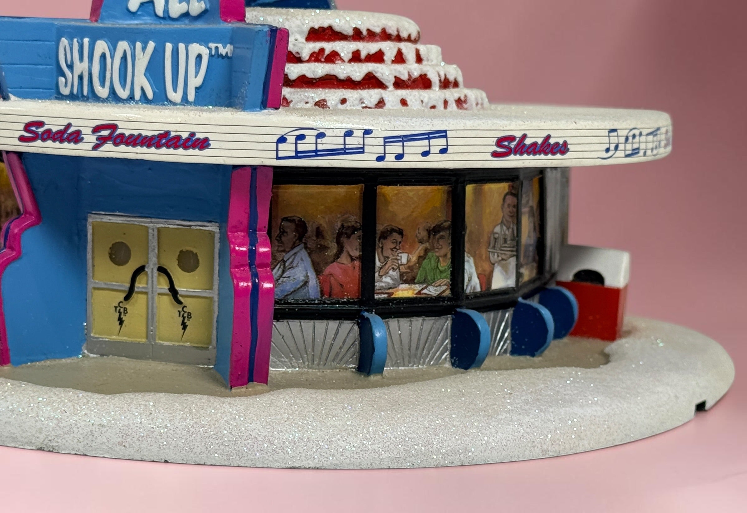 Official 2005 Hawthorne Village “All Shook Up” Soda Fountain from the Elvis Presley Rock ‘n’ Roll Holiday Village collection, featuring colorful retro diner details and snowy accents.