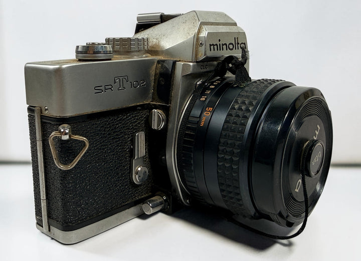 Vintage Minolta SRT 102 35 mm film camera with MC Rokkor-X 50 mm f/1.7 lens, made in Japan. Classic manual-focus SLR sold in untested condition.