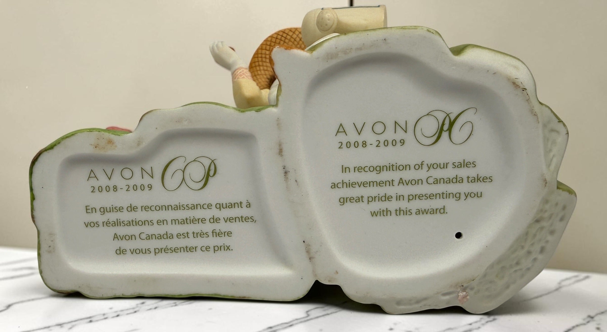 Vintage Avon Canada Mrs. Albee President’s Club 2008–2009 porcelain figurine featuring a detailed garden scene with flowers and watering can.