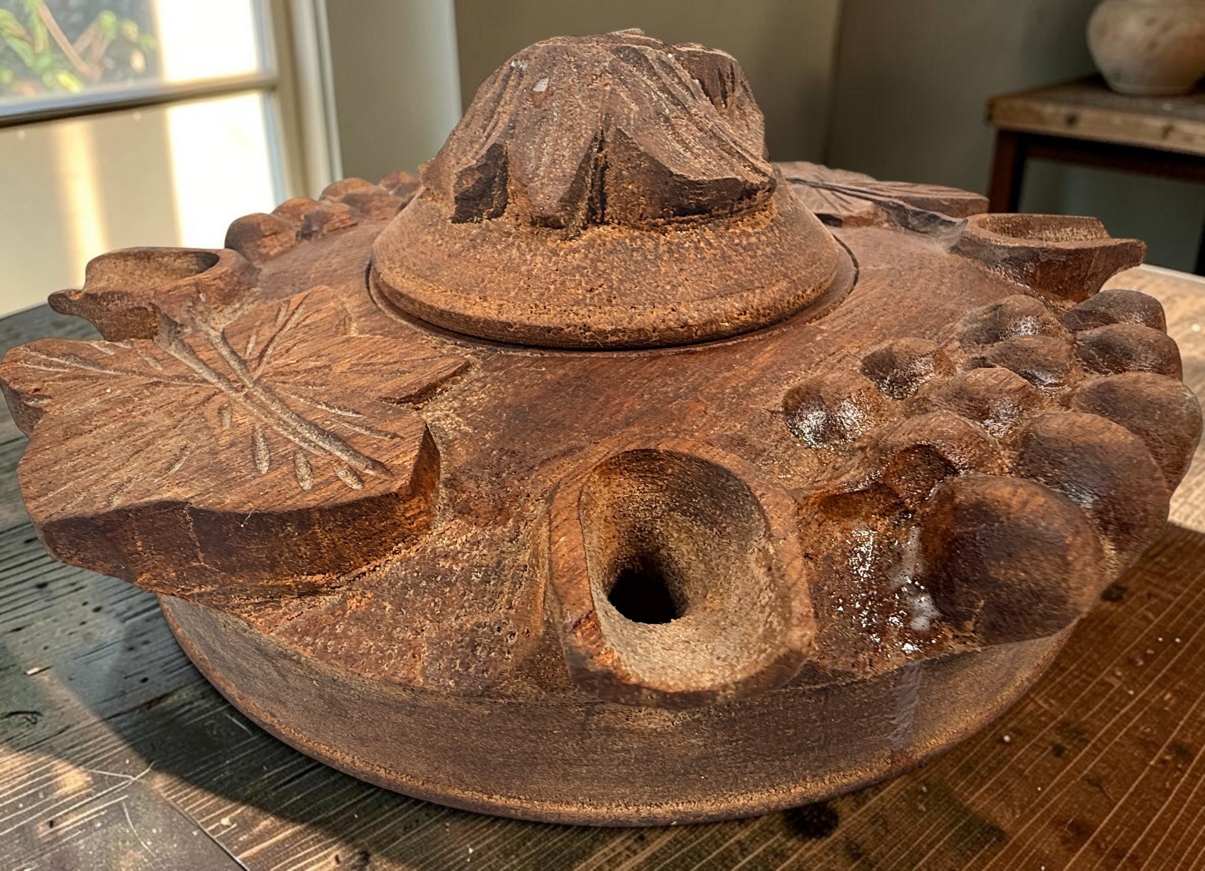 Vintage Savoyard wooden grolle with 4 drinking spouts, carved grapes and vine leaves. Traditional French Alpine communal coffee vessel and folk art.