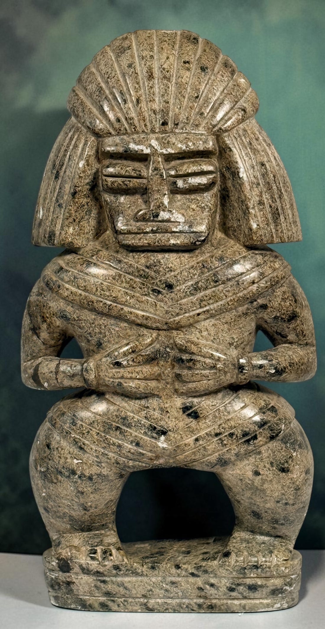 Hand-carved stone warrior figure in Pre-Columbian Mesoamerican style with detailed headdress and geometric features. Unique vintage decorative sculpture.