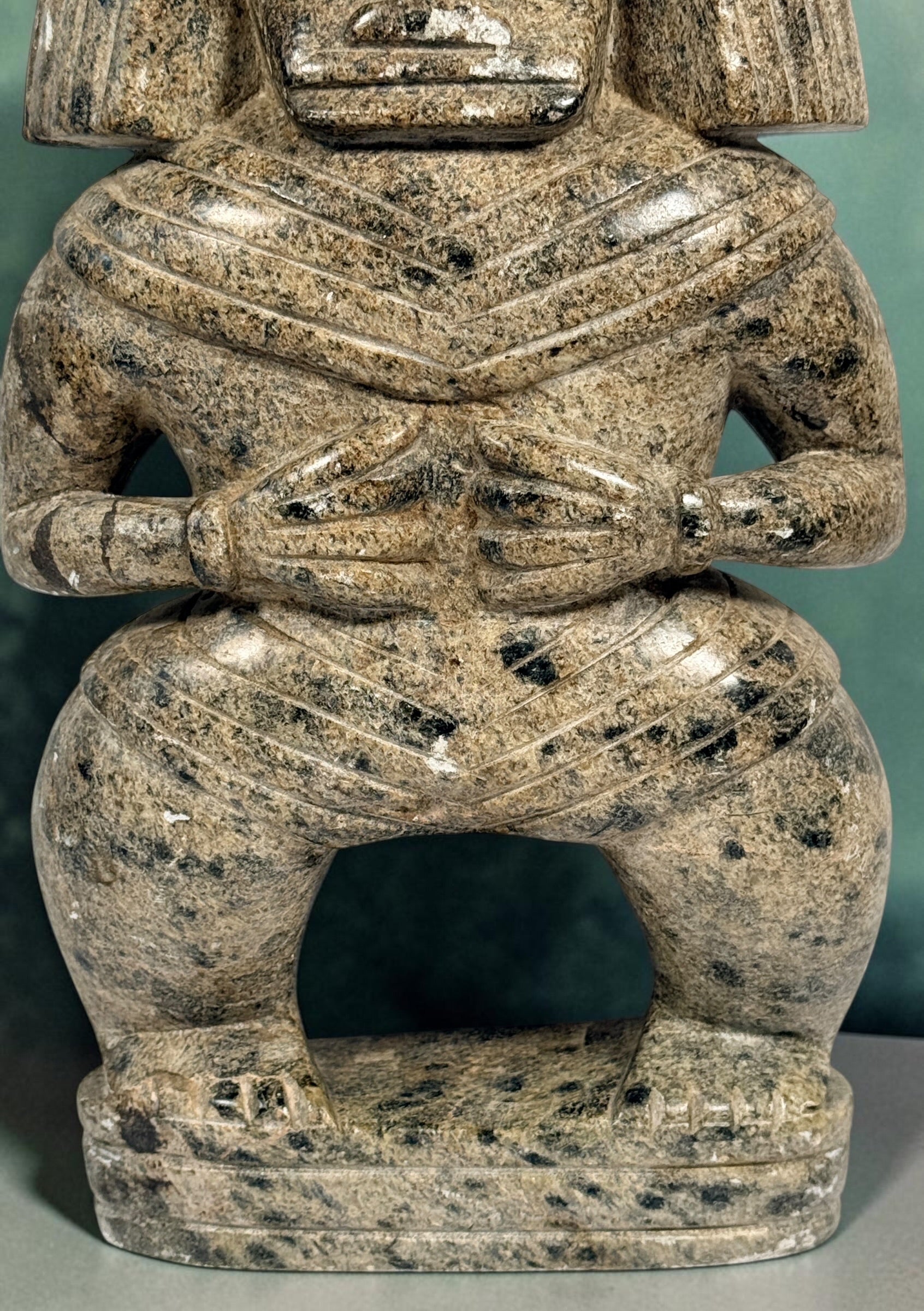Hand-carved stone warrior figure in Pre-Columbian Mesoamerican style with detailed headdress and geometric features. Unique vintage decorative sculpture.