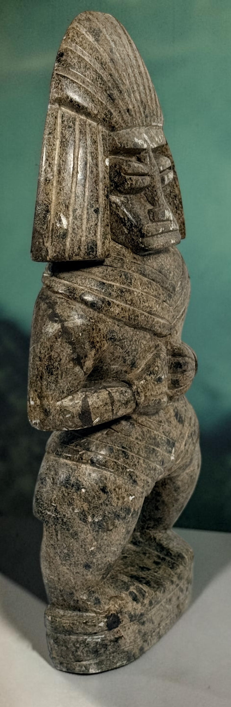 Hand-carved stone warrior figure in Pre-Columbian Mesoamerican style with detailed headdress and geometric features. Unique vintage decorative sculpture.