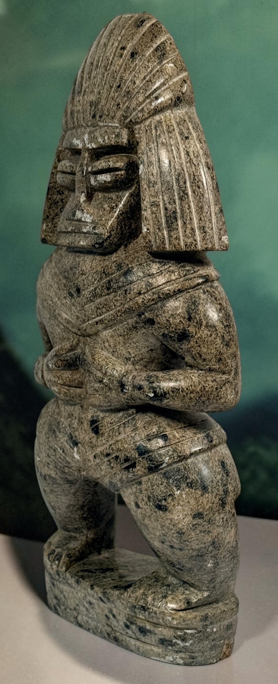 Hand-carved stone warrior figure in Pre-Columbian Mesoamerican style with detailed headdress and geometric features. Unique vintage decorative sculpture.