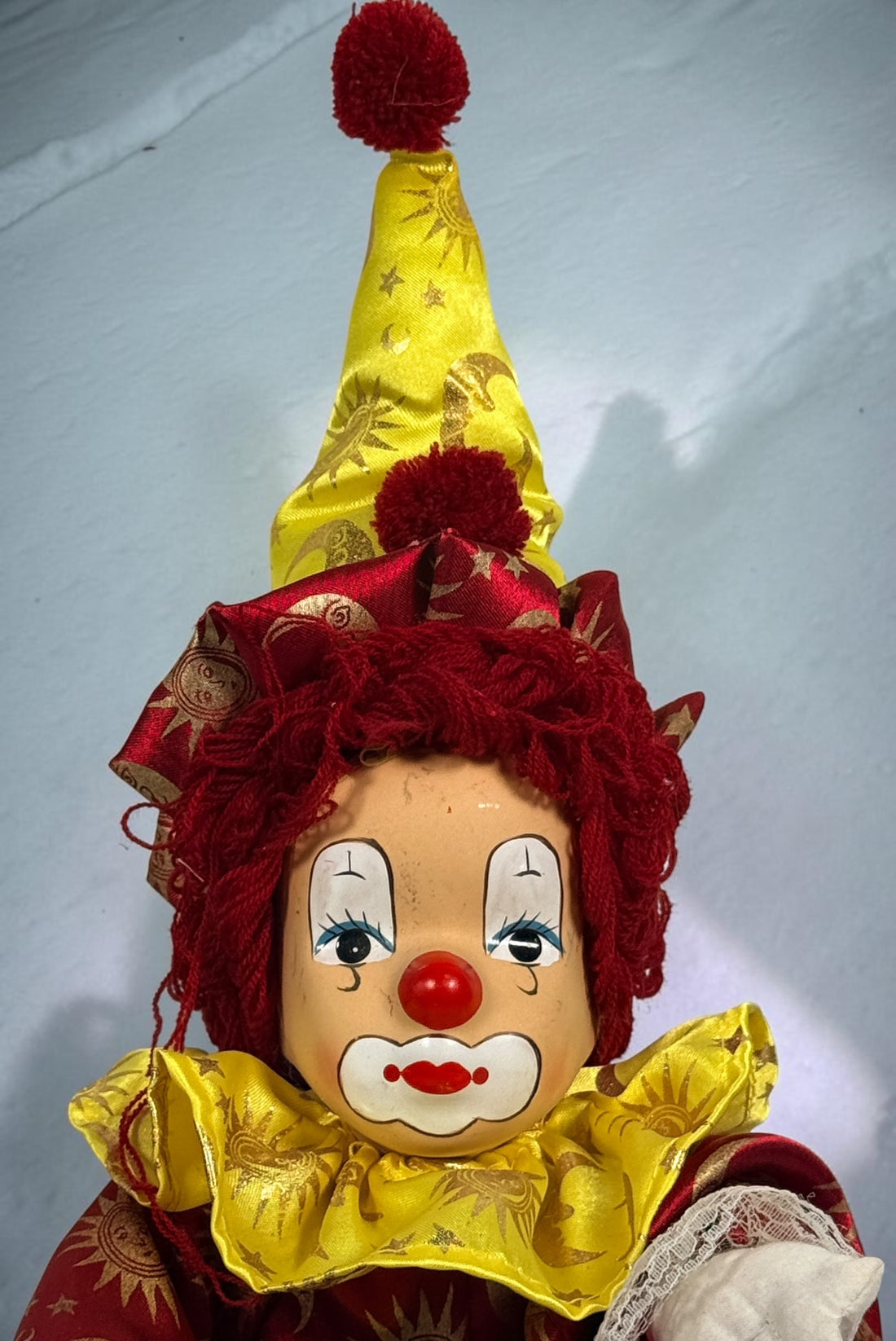 SEO Meta Description: Vintage 12-inch Pierrot clown doll with red and gold celestial costume, yarn hair and painted face. Distinctive collectible circus décor.