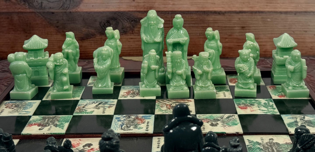 Vintage Chinese 32-piece figural chess set with jade-coloured pieces, carved dragon folding wood board, illustrated squares and fitted storage.