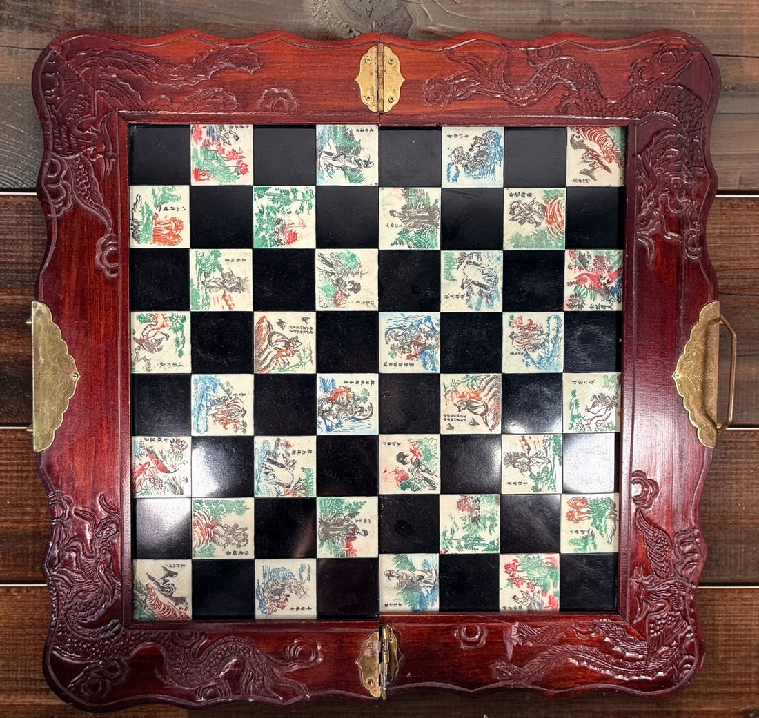 Vintage Chinese 32-piece figural chess set with jade-coloured pieces, carved dragon folding wood board, illustrated squares and fitted storage.