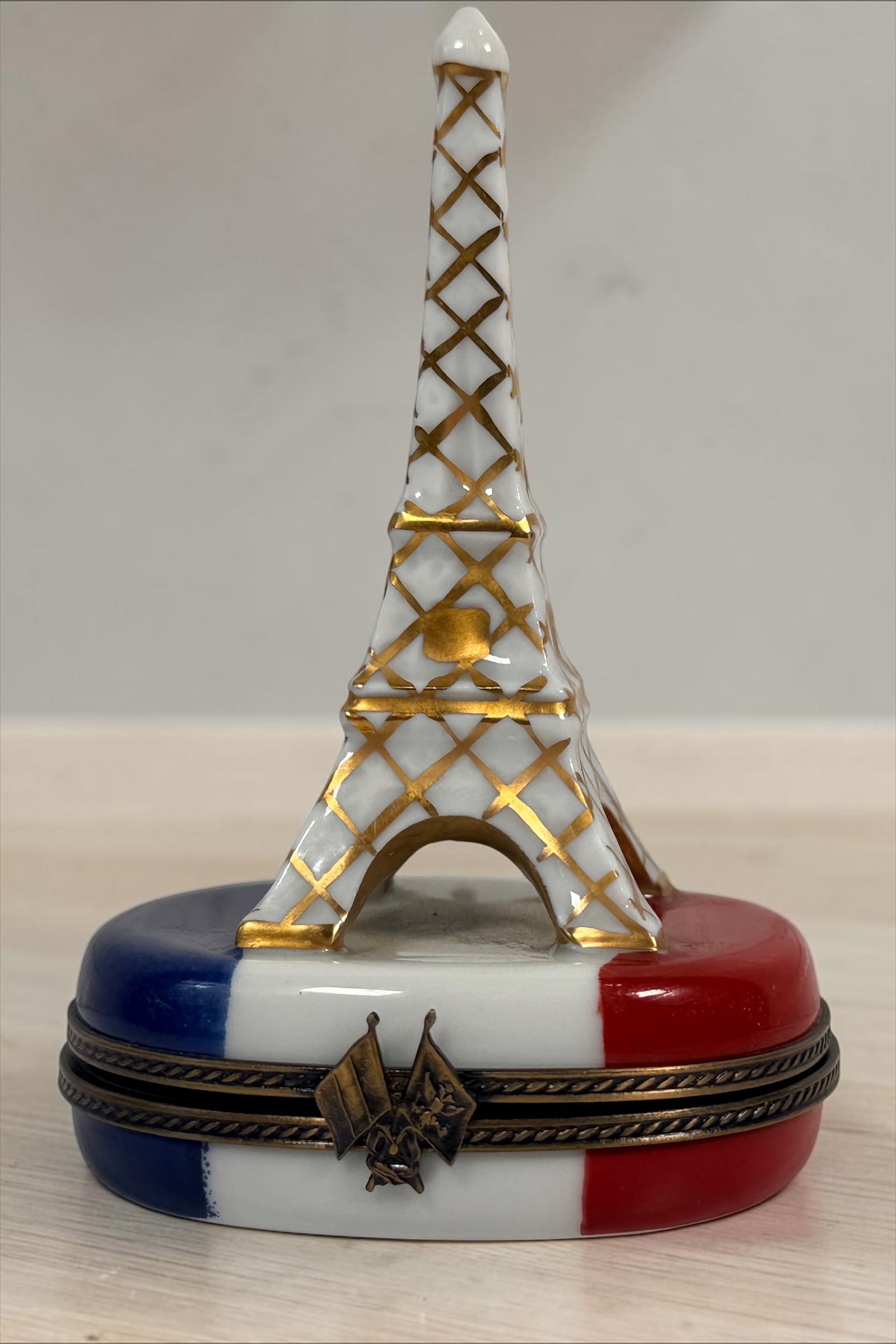 Hand-painted Limoges France Eiffel Tower porcelain trinket box with French tricolour design, gilt detailing and decorative flag clasp.