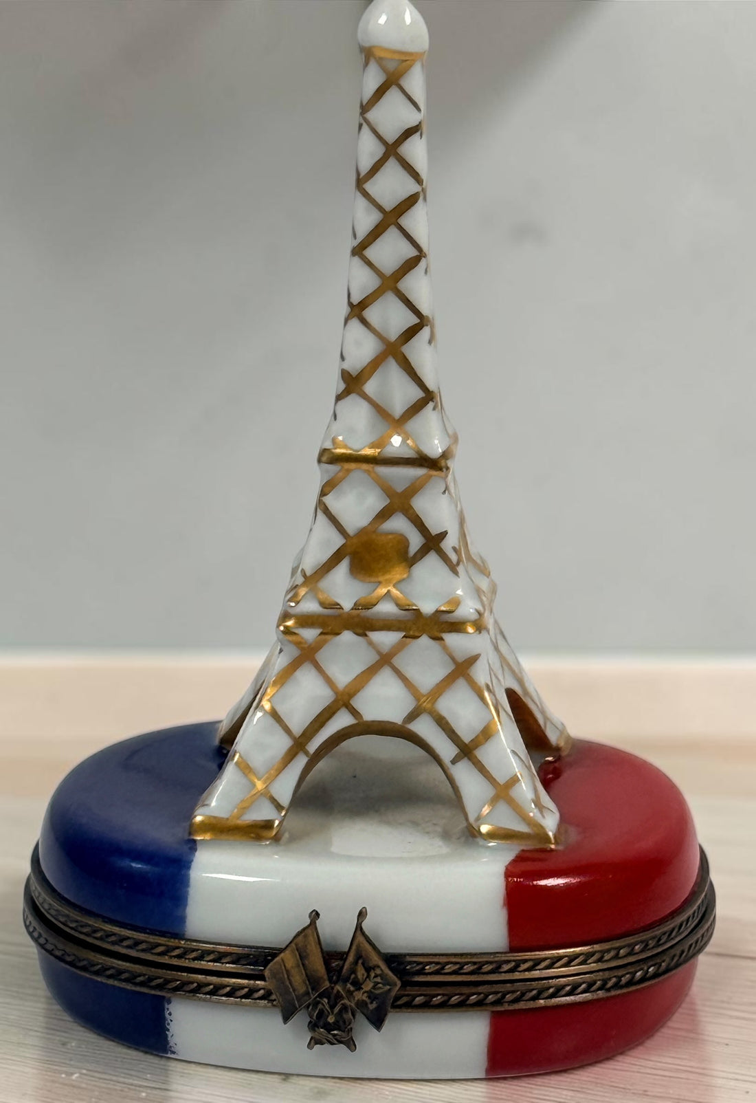 Hand-painted Limoges France Eiffel Tower porcelain trinket box with French tricolour design, gilt detailing and decorative flag clasp.