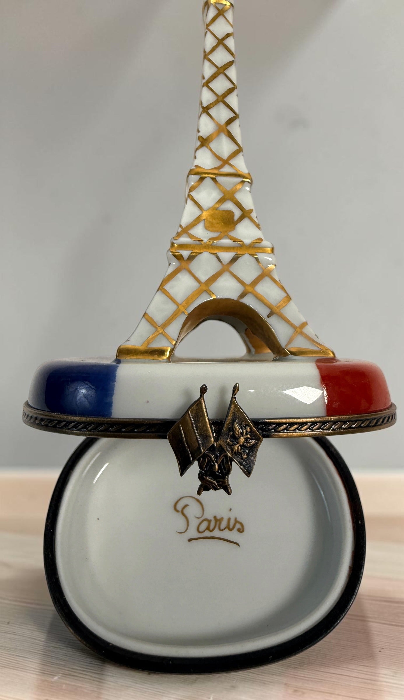 Hand-painted Limoges France Eiffel Tower porcelain trinket box with French tricolour design, gilt detailing and decorative flag clasp.