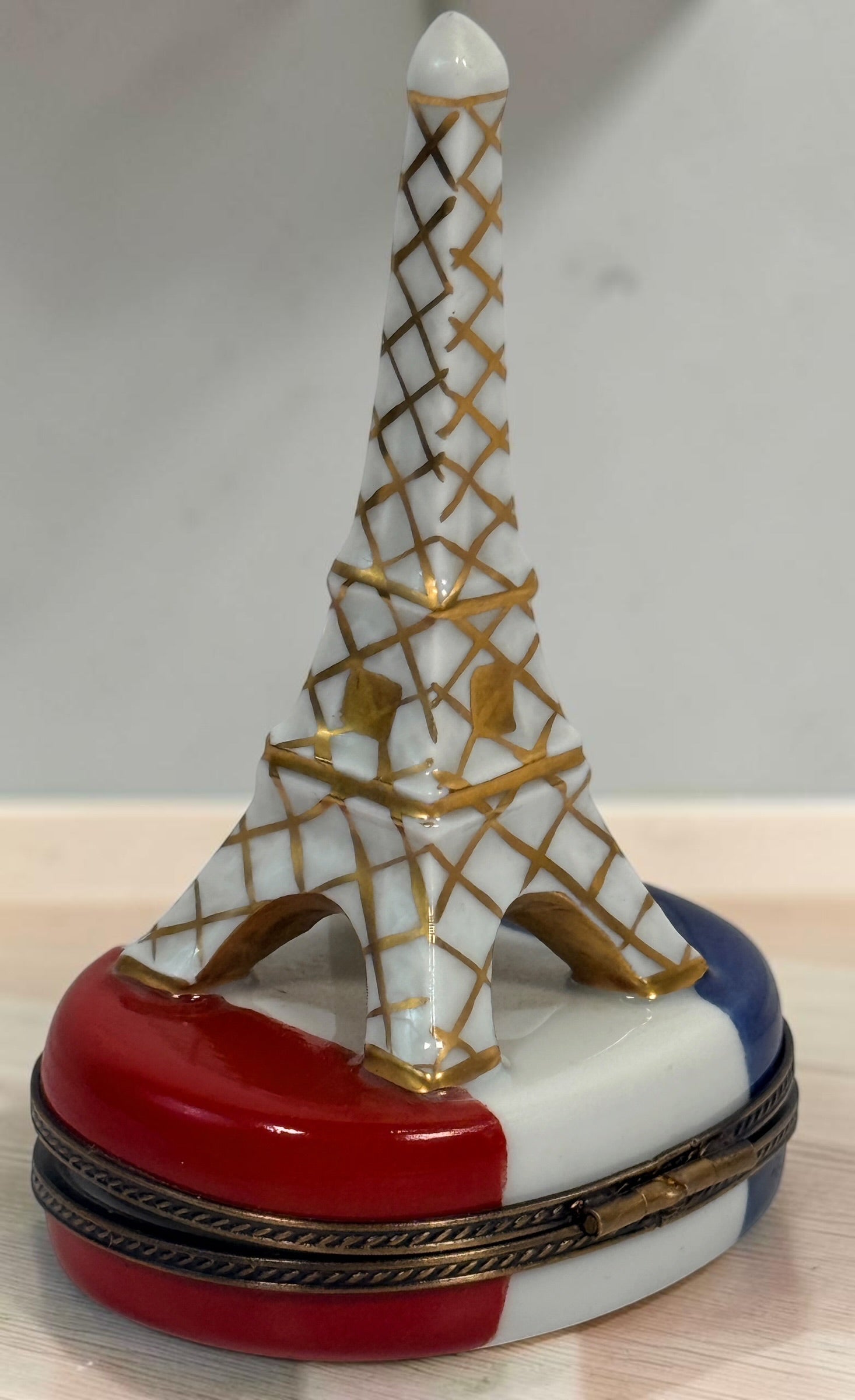 Hand-painted Limoges France Eiffel Tower porcelain trinket box with French tricolour design, gilt detailing and decorative flag clasp.