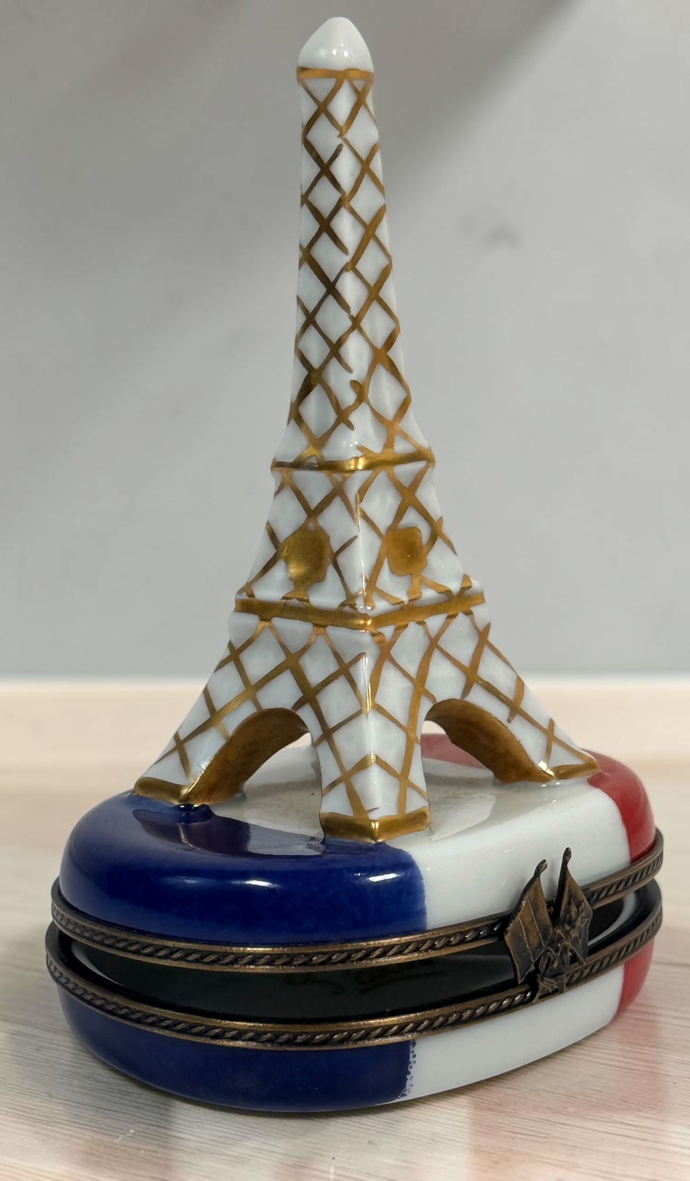 Hand-painted Limoges France Eiffel Tower porcelain trinket box with French tricolour design, gilt detailing and decorative flag clasp.