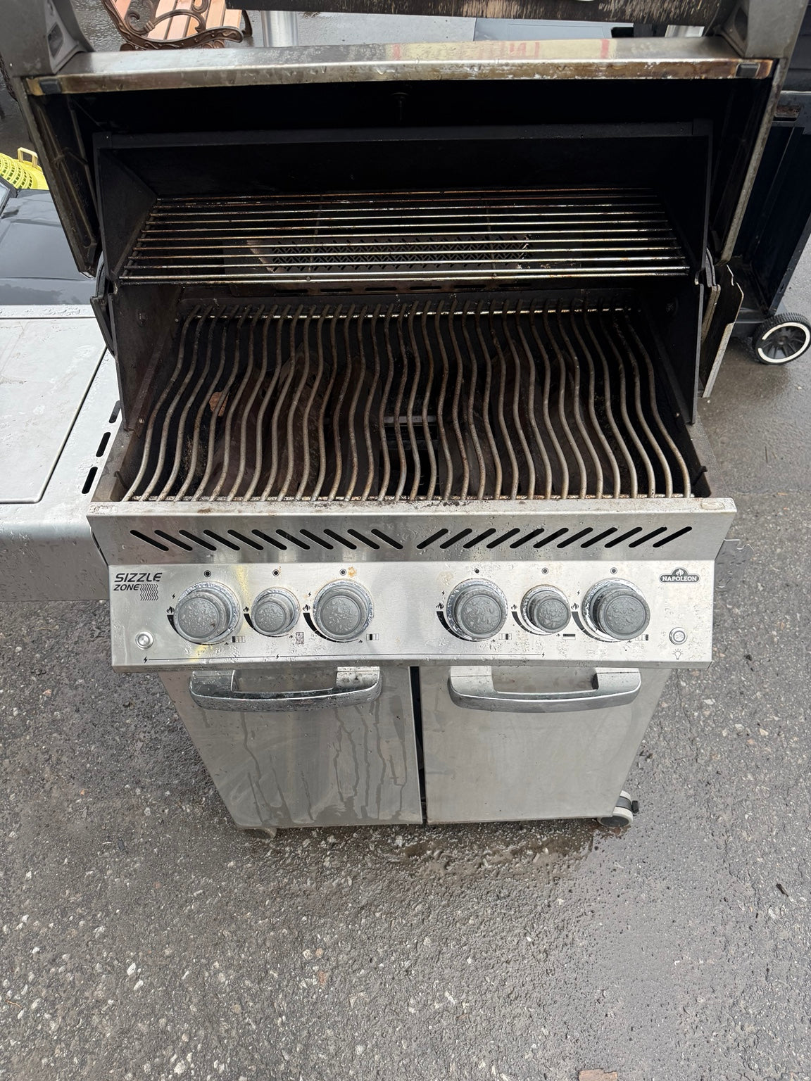 Used Napoleon BBQ with lid open, showing cooking grates and warming rack