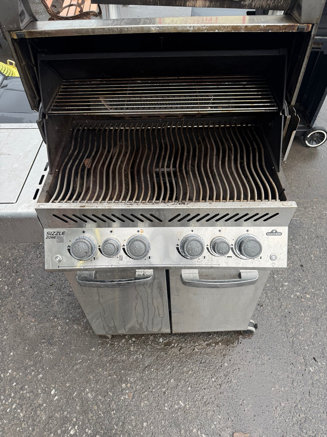 Used Napoleon BBQ with lid open, showing cooking grates and warming rack