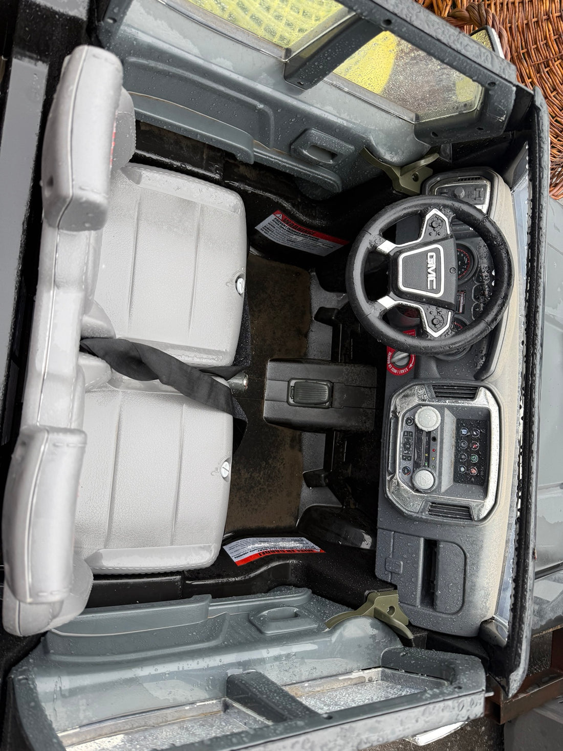 Interior of GMC Denali ride-on toy truck showing seats, steering wheel and dashboard