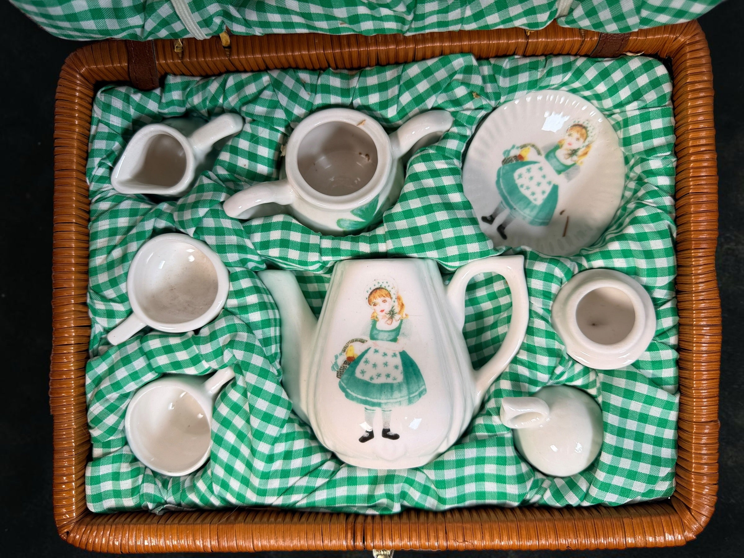 Vintage Delton miniature ceramic tea set with Irish girl and shamrock designs, complete with green gingham-lined wicker picnic basket.